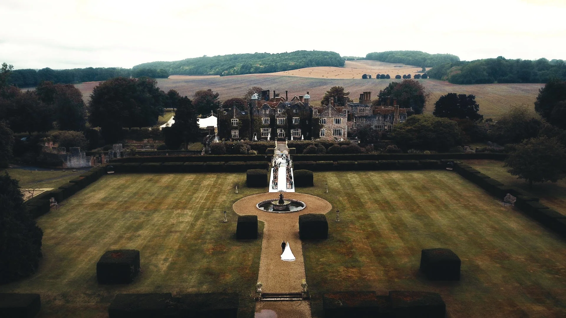 A drone shot captures a luxury outdoor wedding ceremony, as part of a cohesive photo and video team spicialising in capturing weddings in an editorial style.