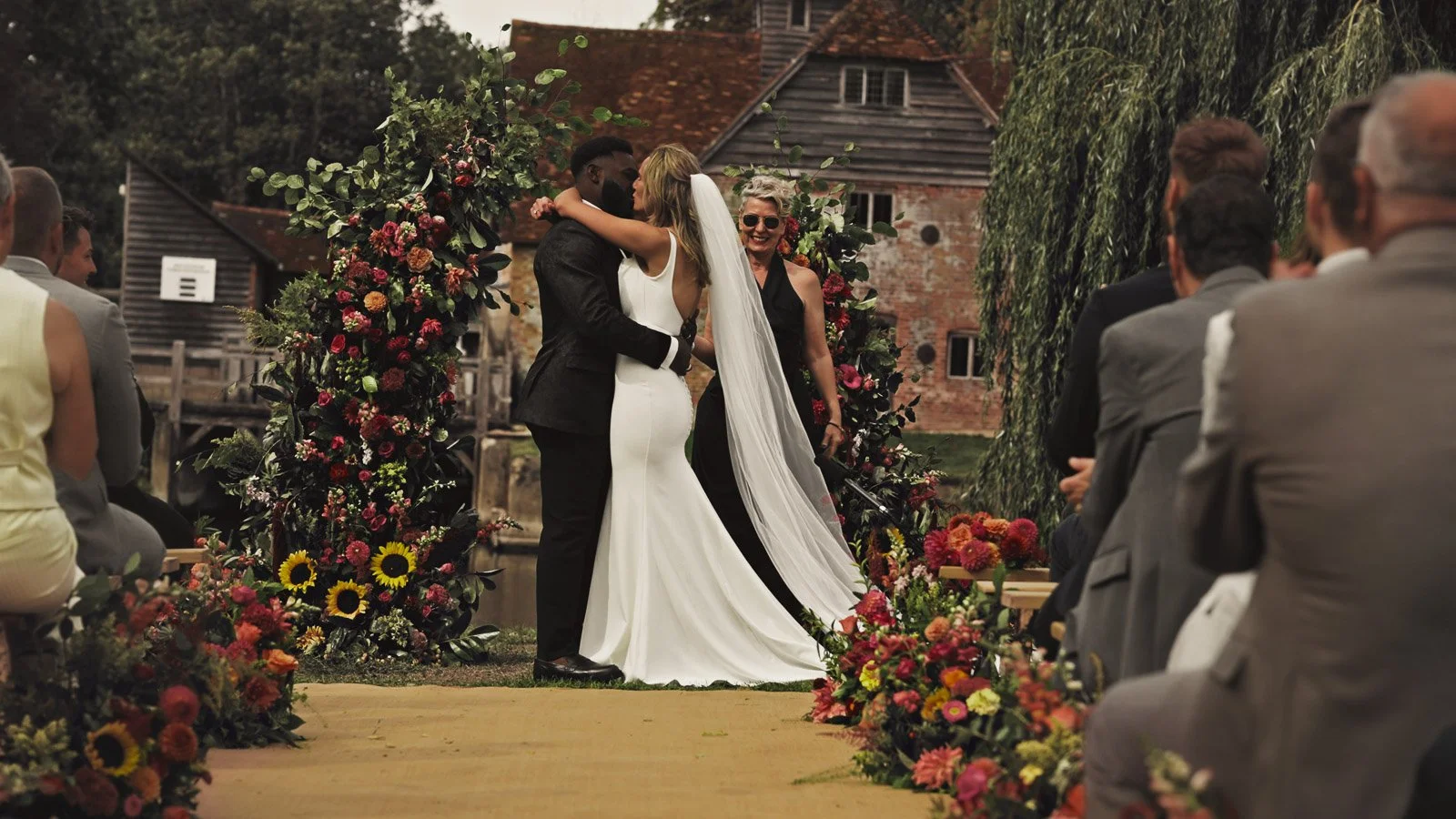 Editorial-style wedding photography from a colourful riverside celebration with bold florals and a marquee reception.