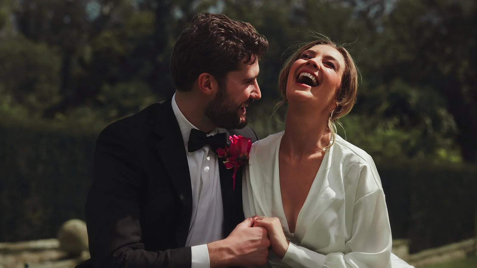A natural moment from an editorial and fine art wedding film, as the bride laughs with her groom during their black tie celebration.