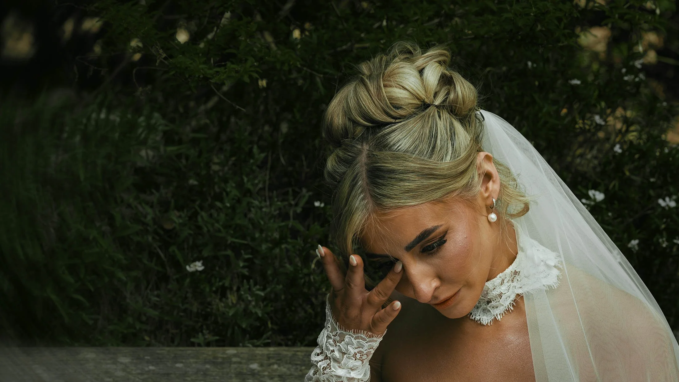 A bride wipes tears away from her eye as she reads a personalised letter written by the groom, taken from a highly-emotive moment during their cinematic wedding film that focusses on narrative and storytelling.