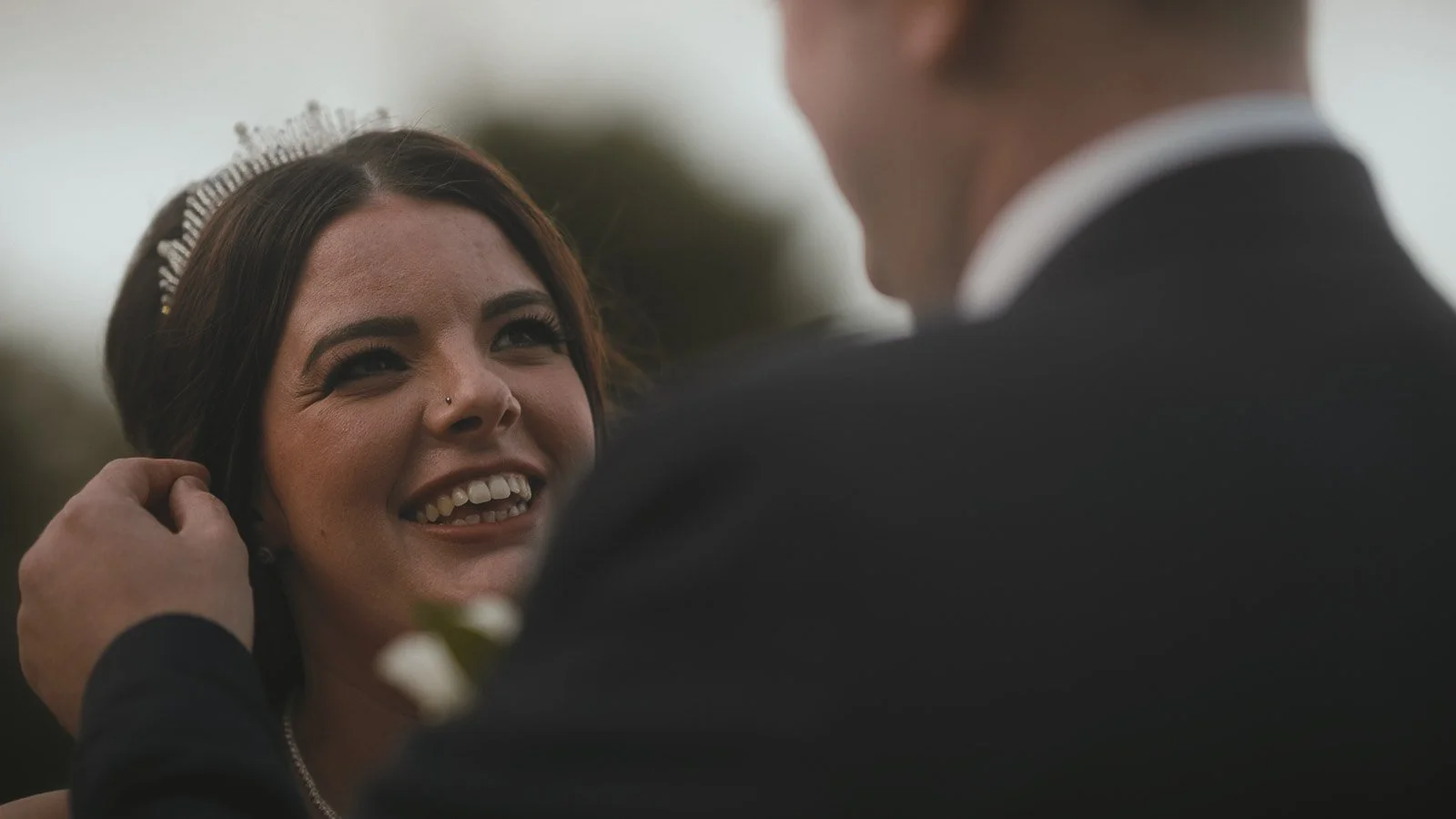 A bride smiles lovingly during a romantic moment at golden hour in a Cooling Castle wedding film.