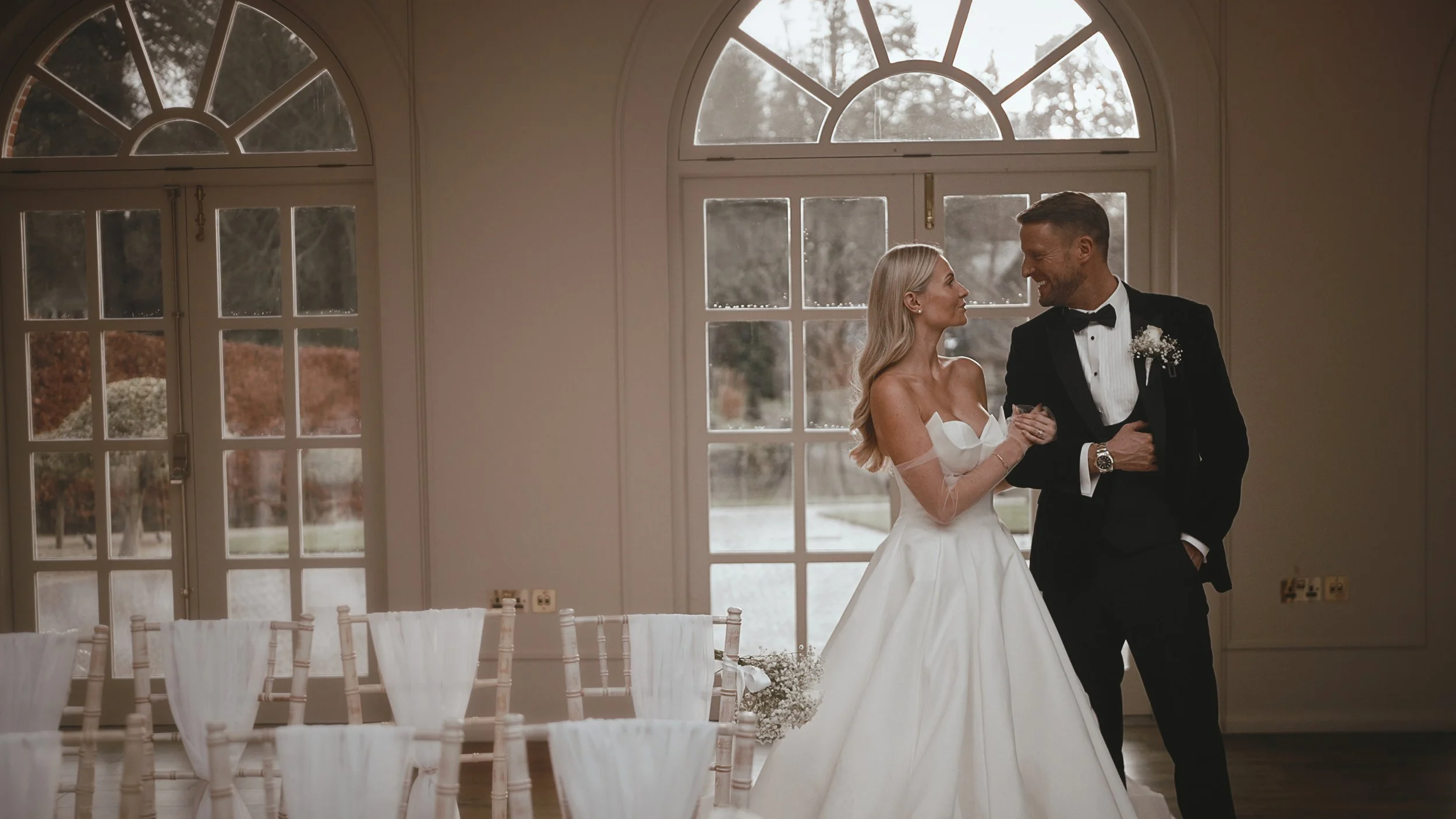 A bride smiles at her groom during their black tie New Years Eve wedding