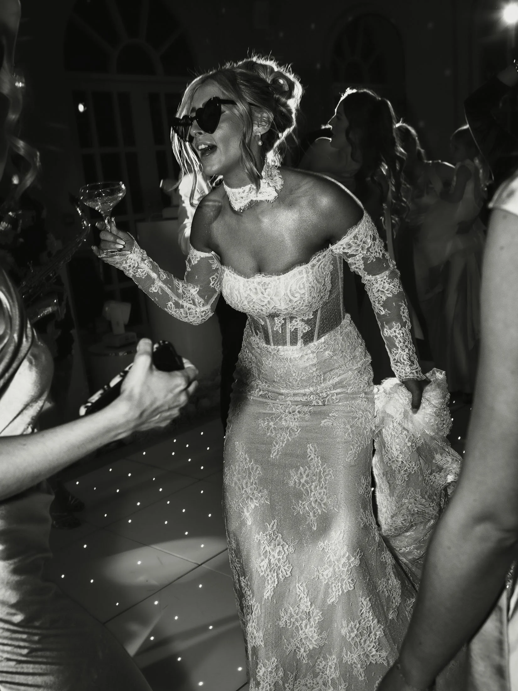 Black and white editorial moment of a bride wearing sunglasses and dancing during evening celebrations at the orangery Maidstone in Kent.