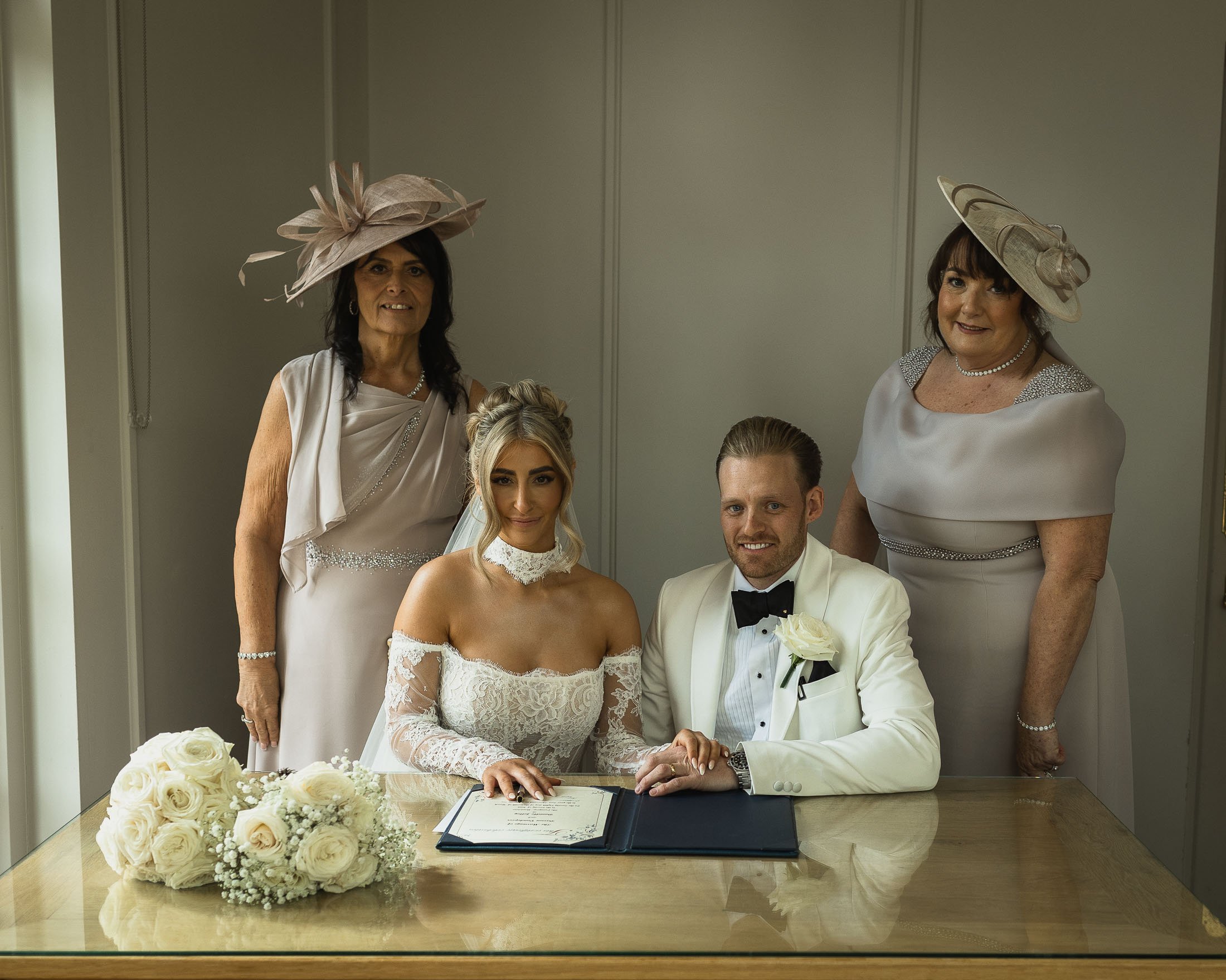 The witnesses stand with the bride and groom after an indoor wedding ceremony at The Orangery Maidstone in Kent.