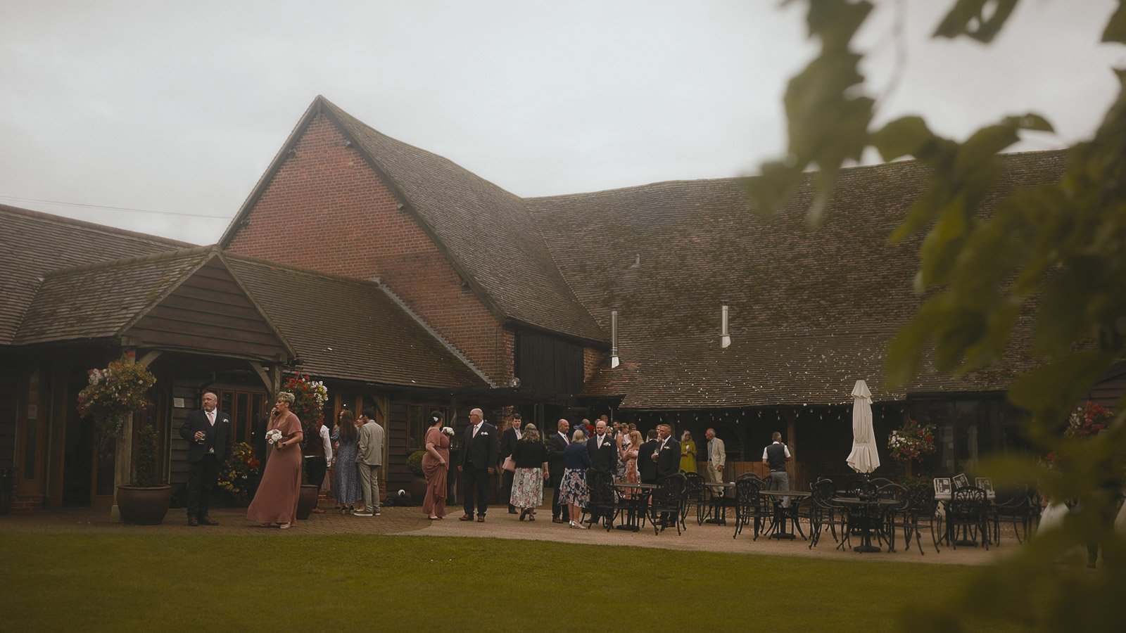 A wide shot of an outdoor wedding reception on the lawn at Cooling Castle Barn.