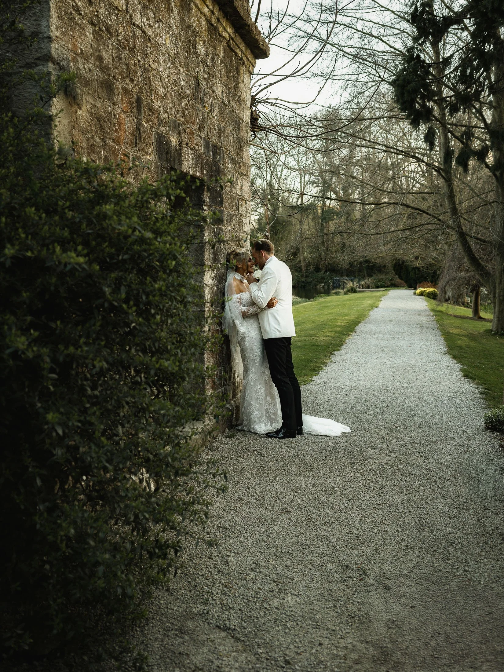 An editorial moment captured by a photo and video team of a bride and groom by the lake at The Orangery Maidstone wedding venue.