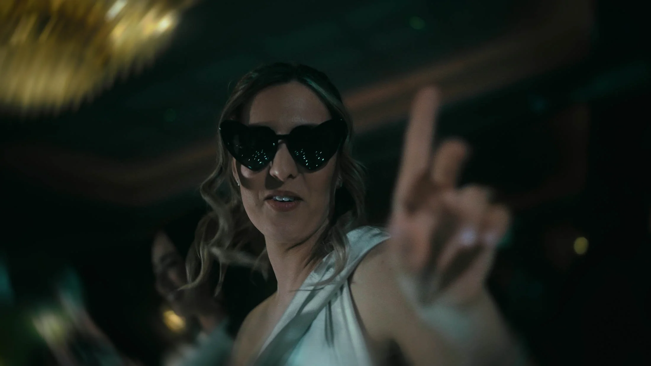 A bridesmaid dances at the camera during a fast-paced high-energy sequence from a storytelling wedding film.