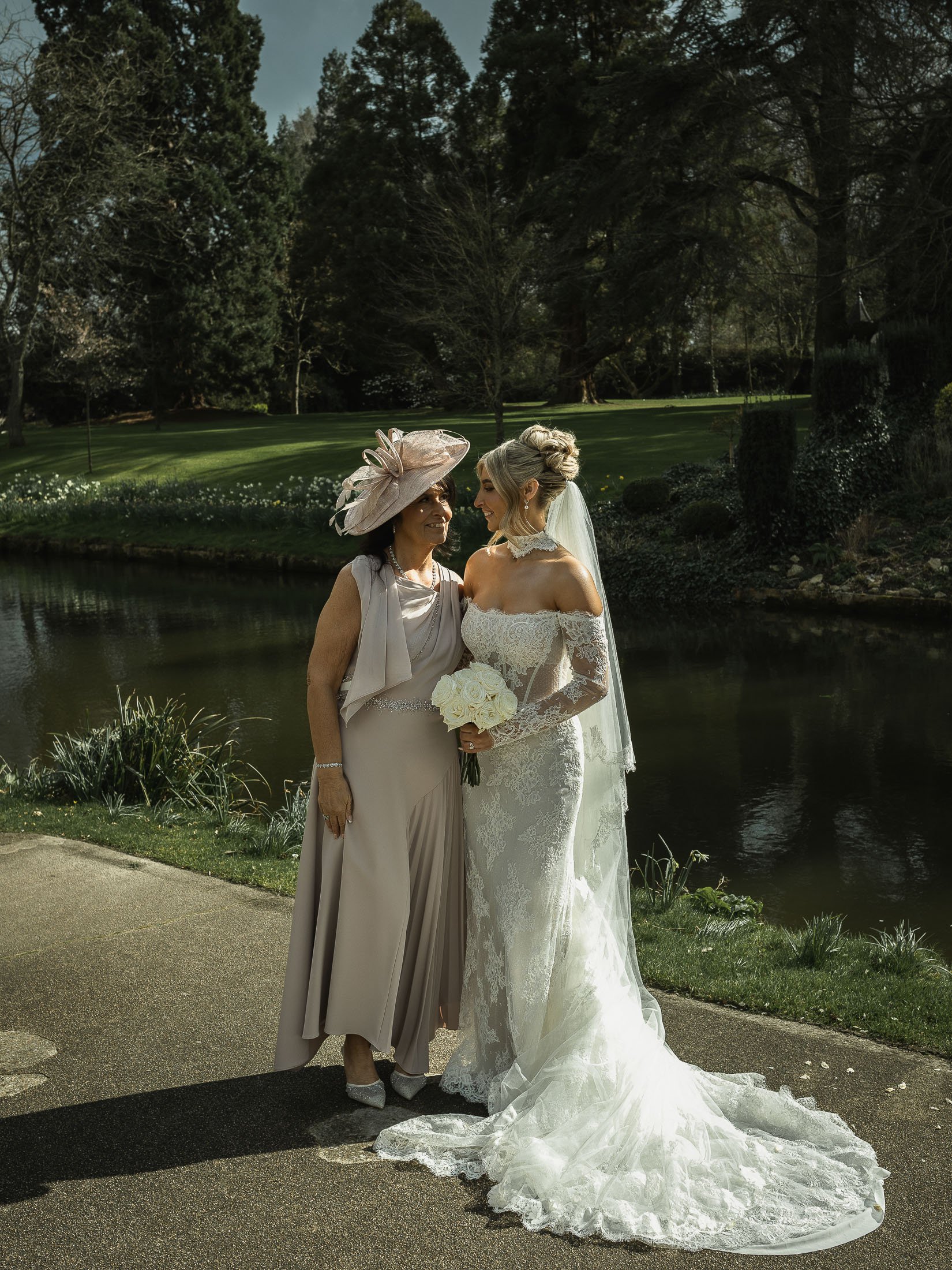 A candid moment between a bride and her Mother by the lake at The Orangery Maidstone.