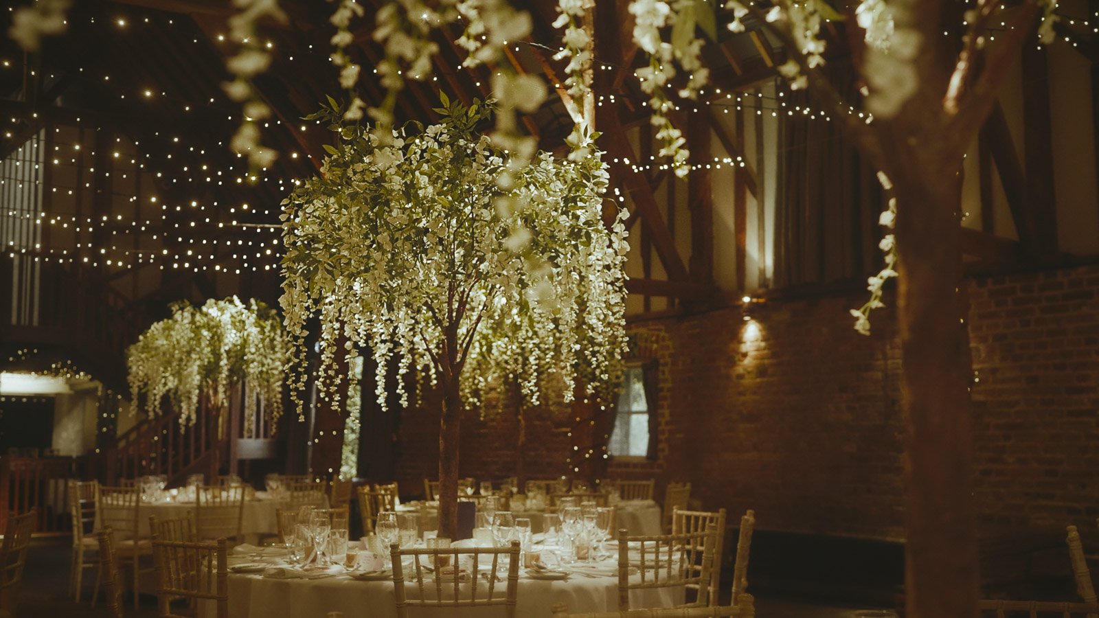 Floral installation styling inside a barn at Cooling Castle Barn wedding venue