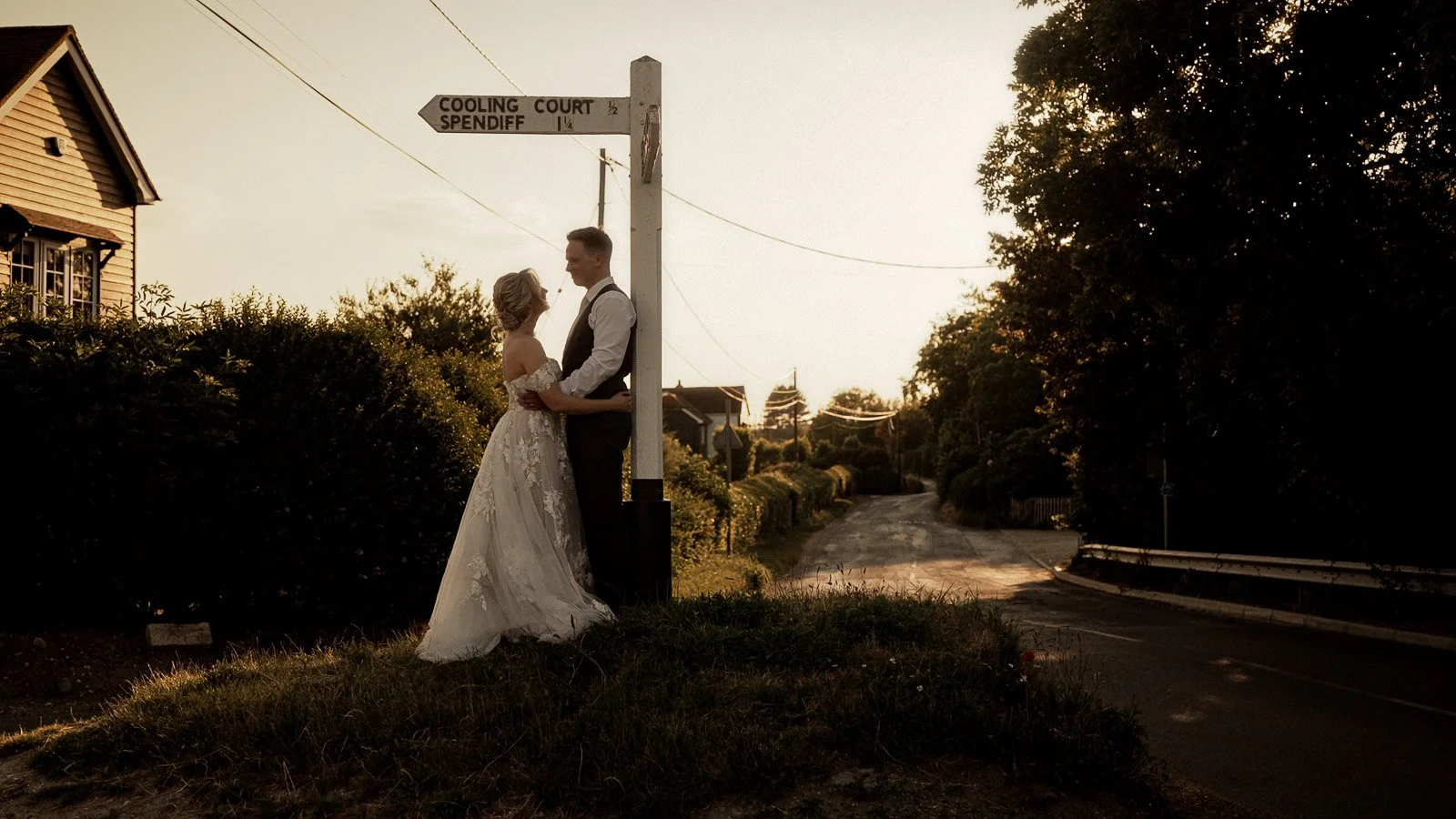 Natural couple moment captured in a Cooling Castle Barn wedding film in Kent as the couple stand by the famous white road sign.