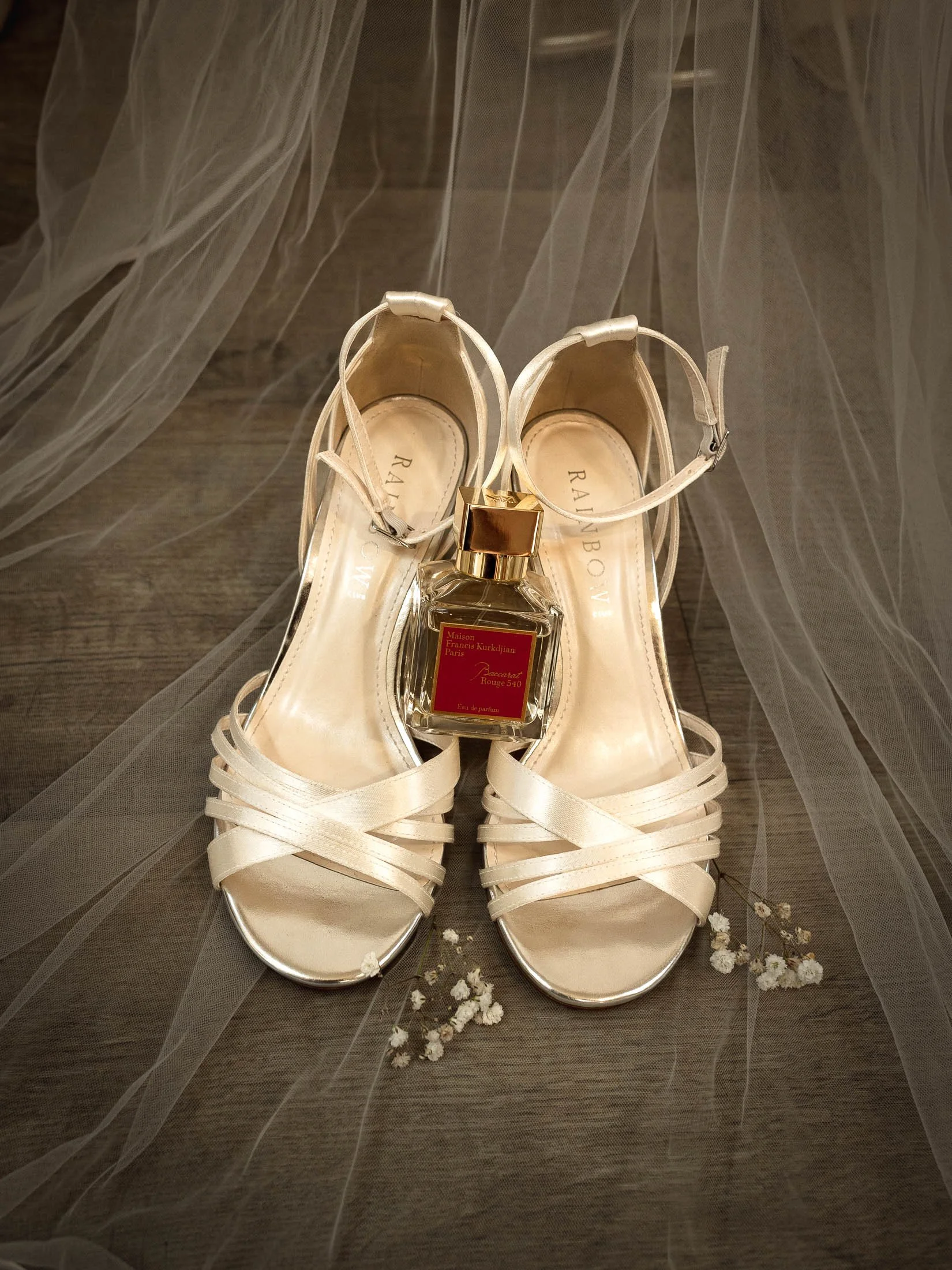 A bridal details wedding photograph, showing the brides shoes, perfume and jewellery. 