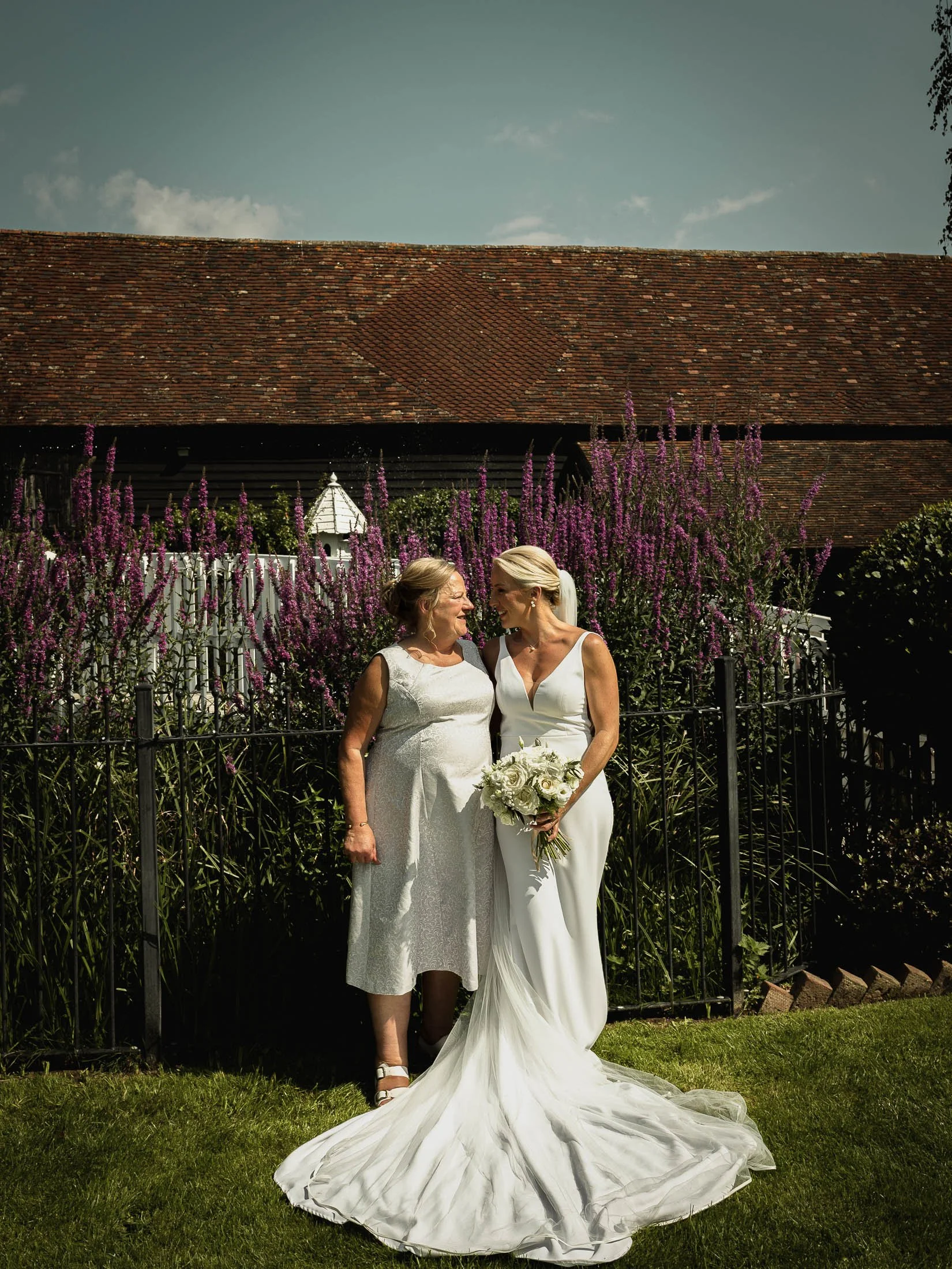 A group portrait in the gardens of Winters Barns, showing a bride smiling at her mother.