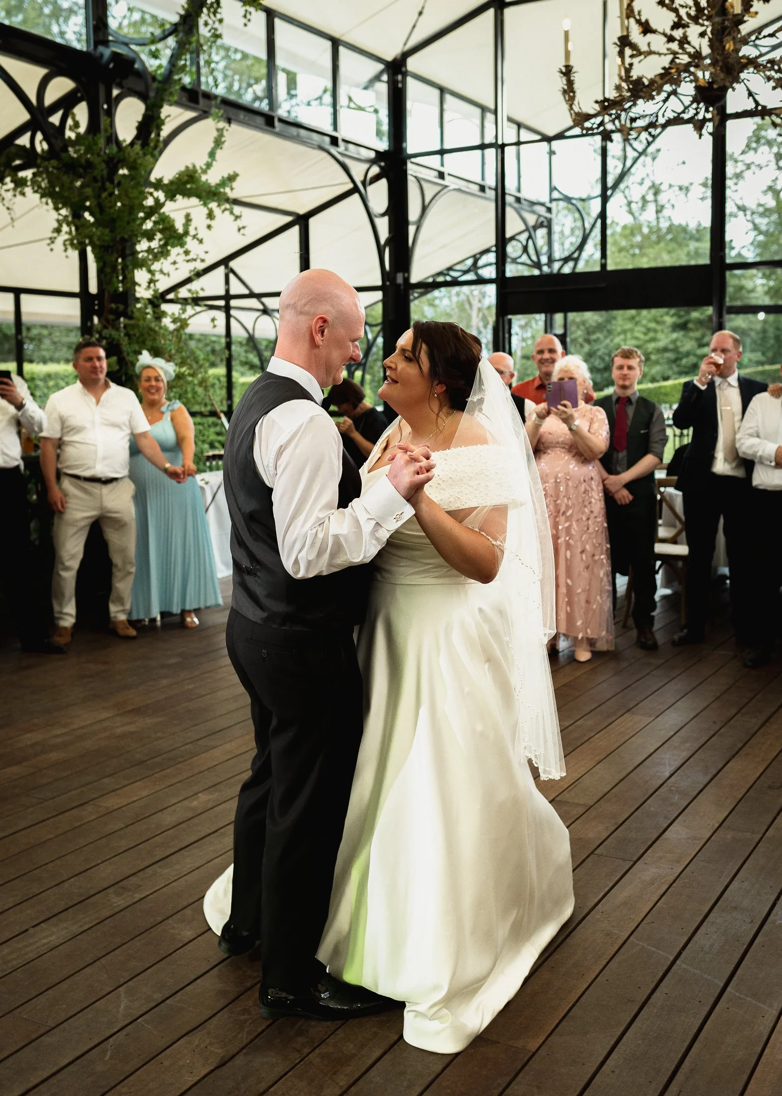 A bride and groom share their first dance in the Glass Orangery during a Port Lympne Hotel wedding.