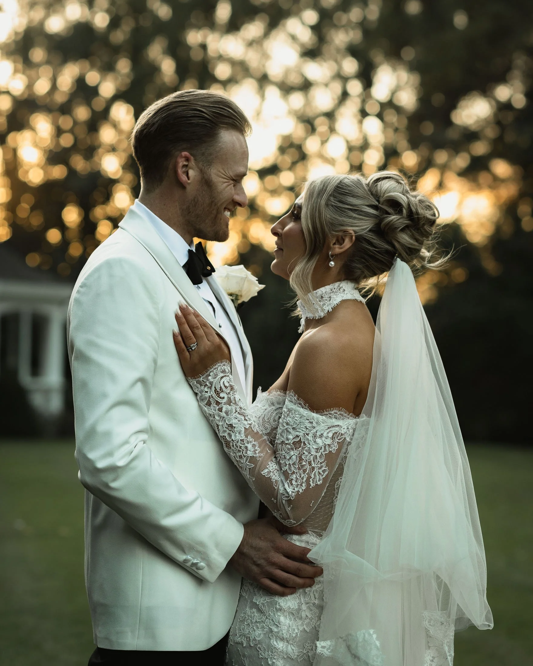 A bride and groom pose together during golden hour portraits at The Orangery Maidstone, as they are captured by both a wedding photographer and videographer.