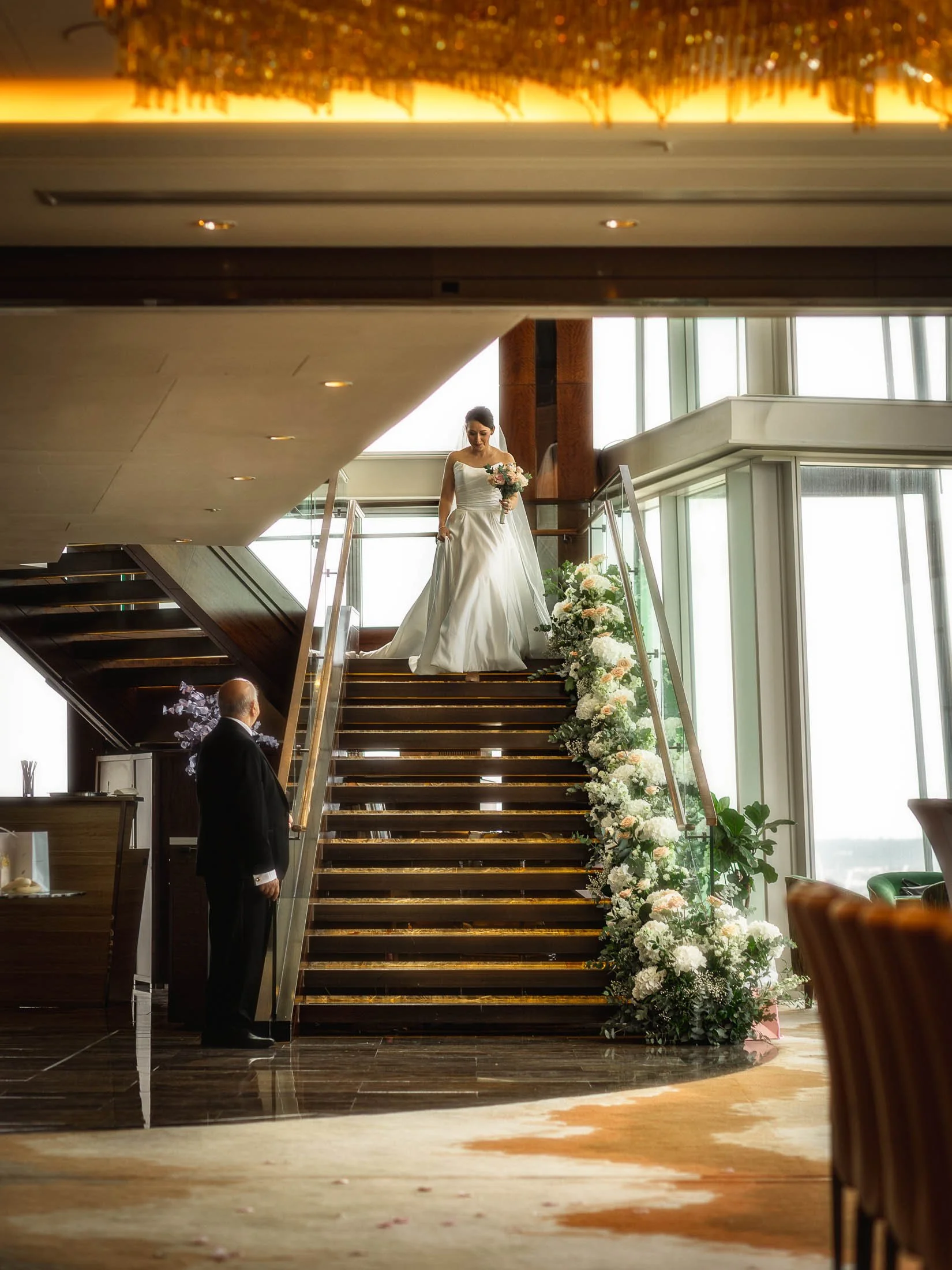 A bride walks down the steps of the Shangri-La Hotel in London as she enters her indoor wedding ceremony on the 34th floor of The Shard.