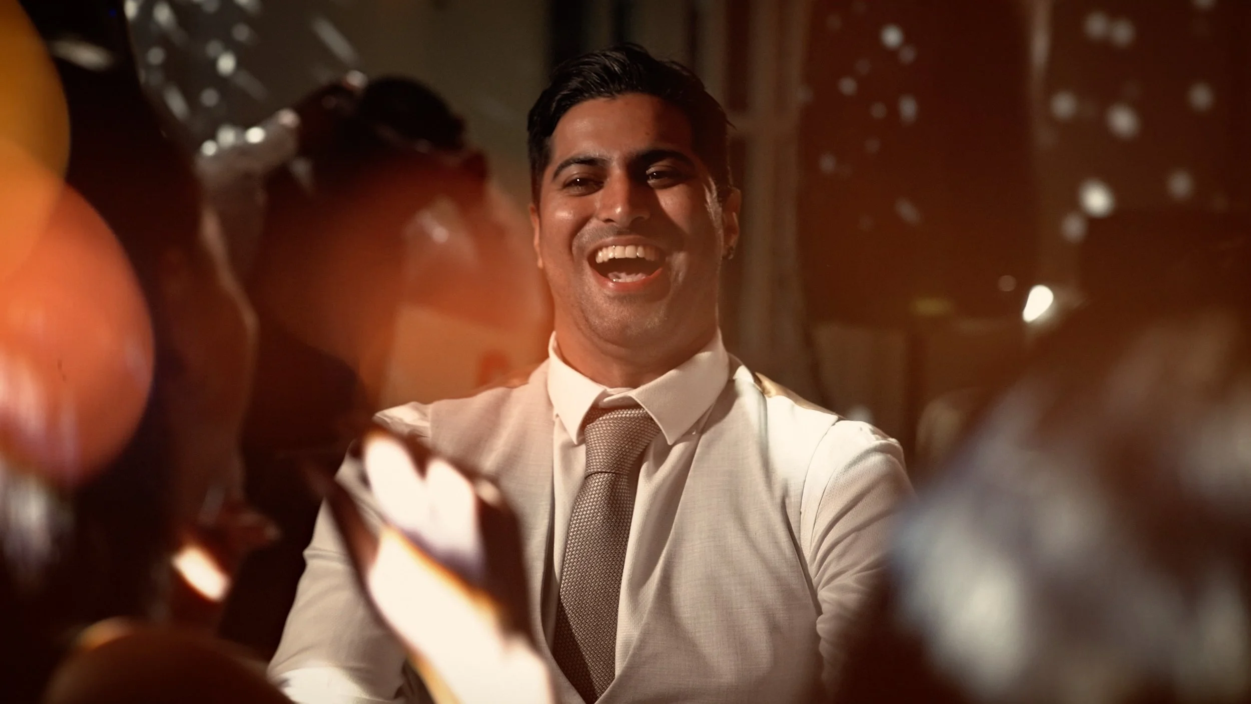 A groomsman laughs on the dance floor at The orangery, maidstone.