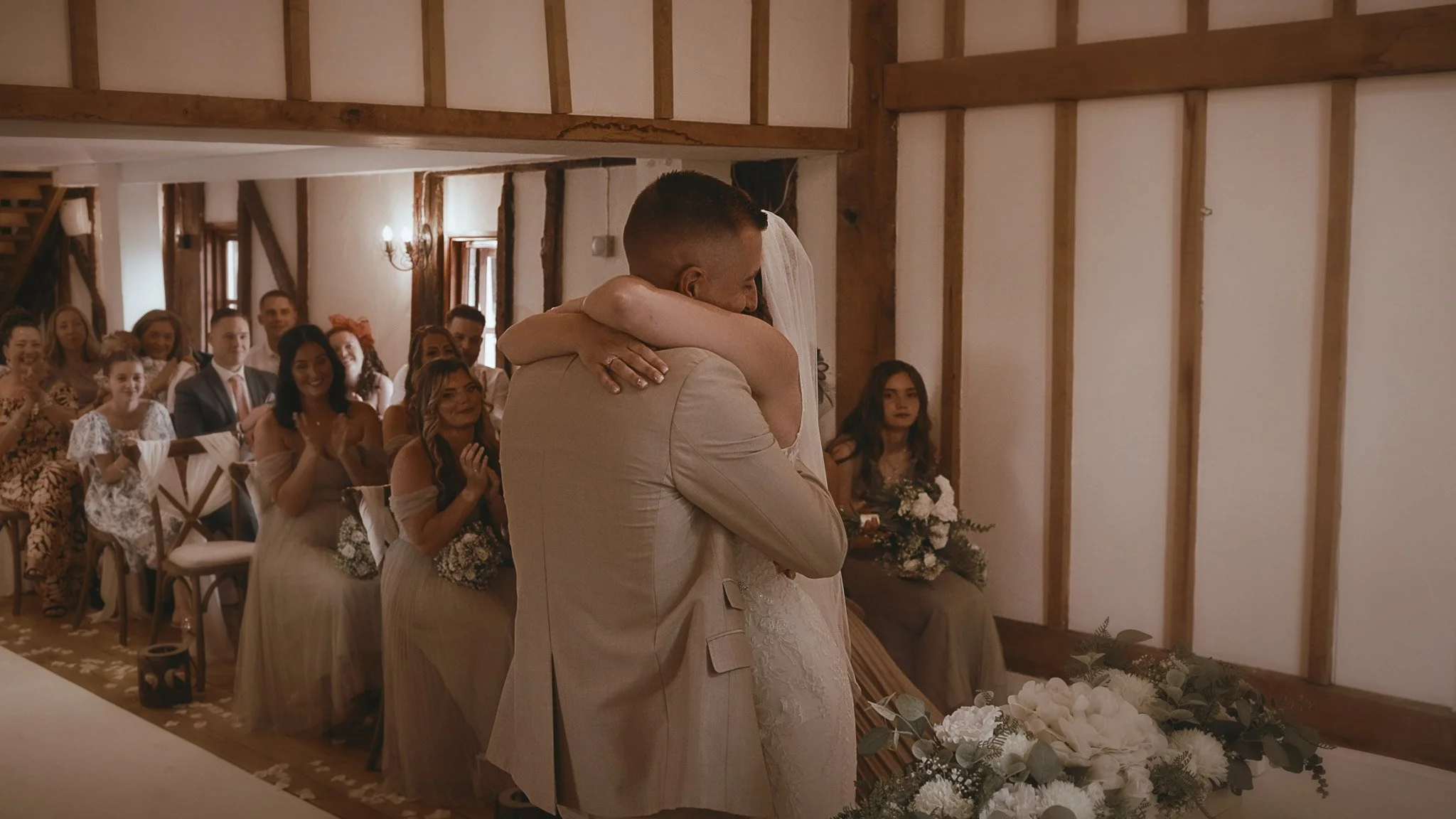 An emotional moment during a Vaulty Manor wedding film as the couple embrace at their wedding ceremony in Essex.