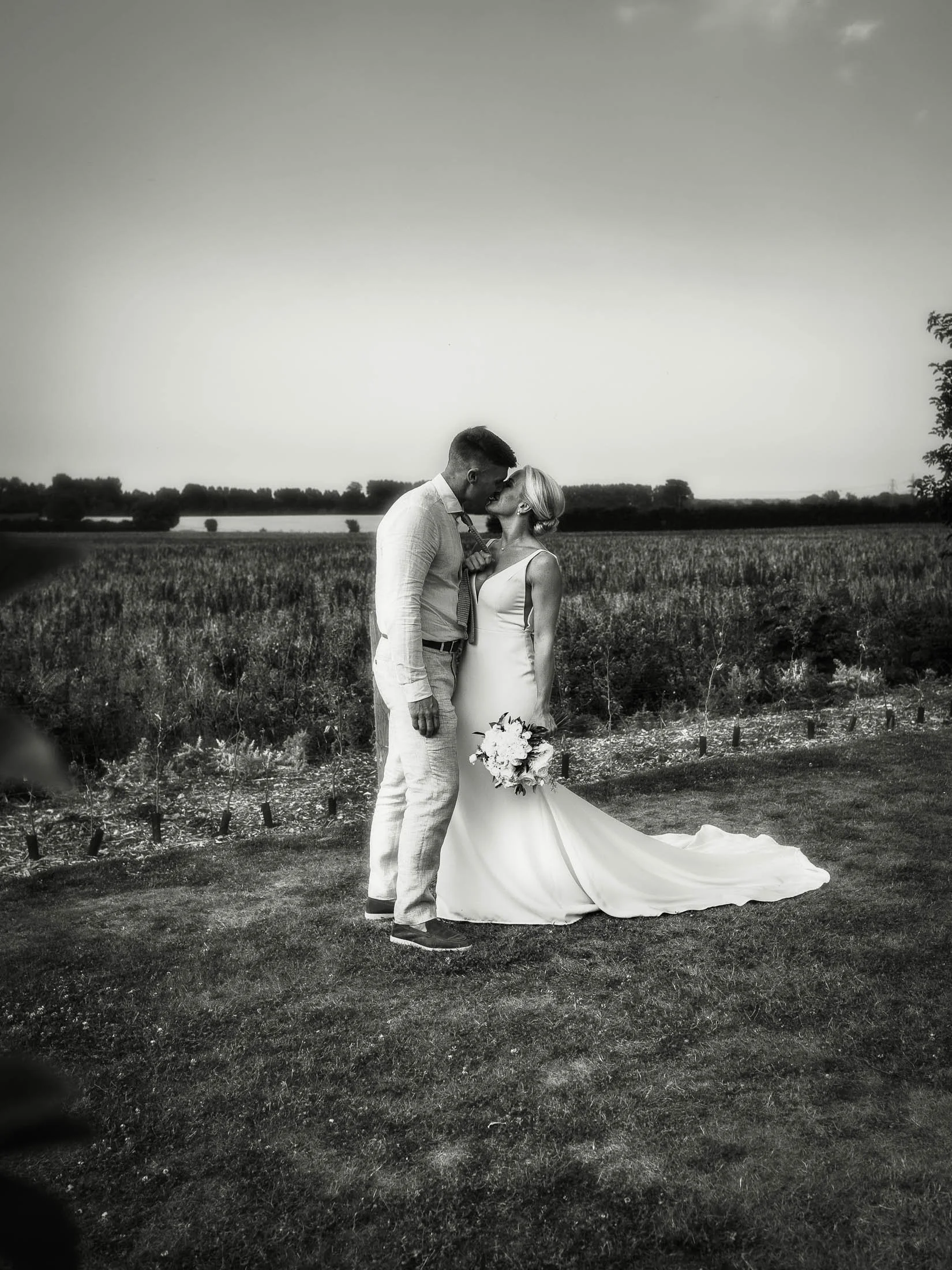 A natural wedding photo of a couple during their golden hour portrait session at Winters Barns in Kent, captured in a black and white aesthetic.