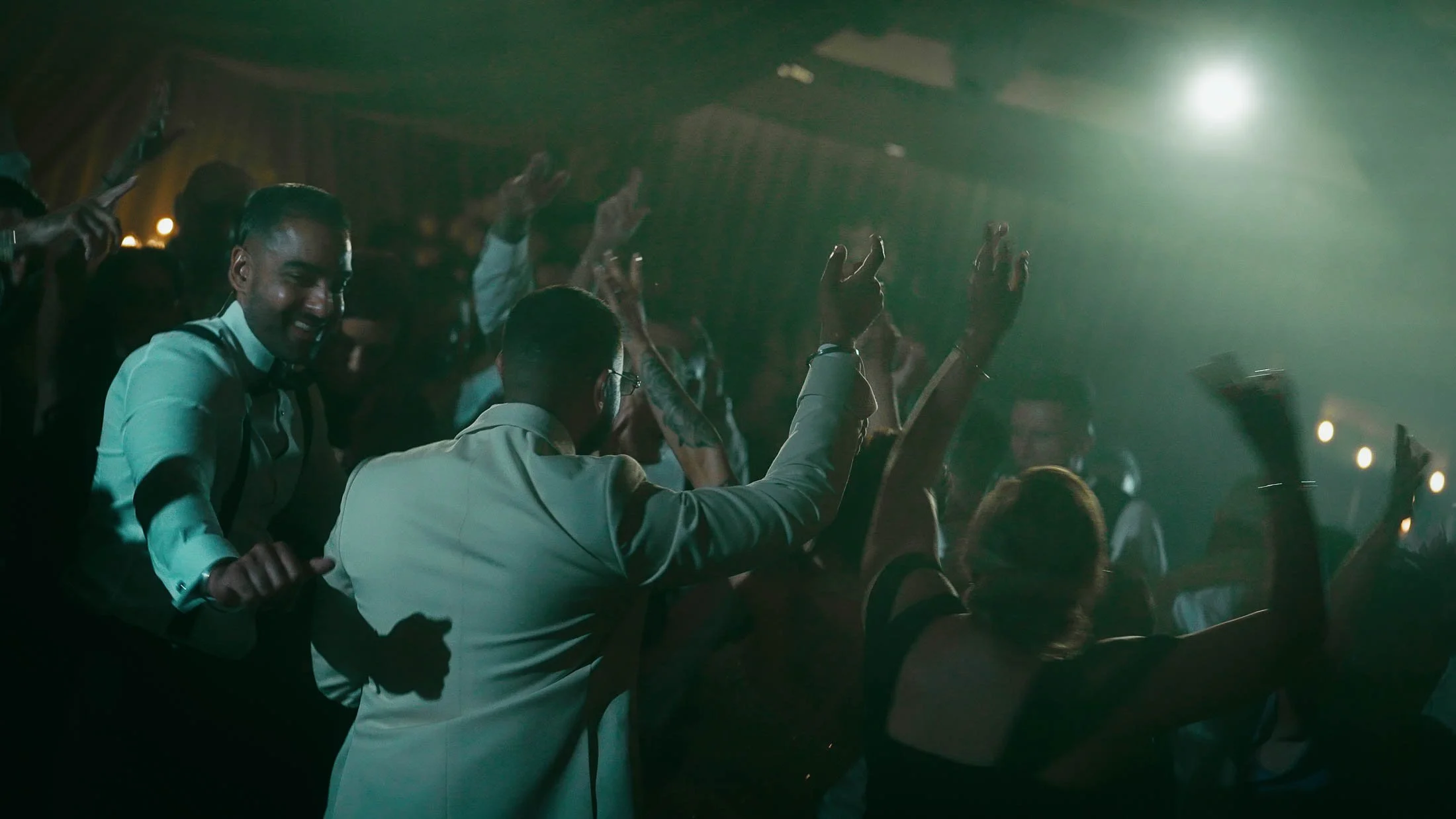 After party scenes in the Grantley Suite as wedding guests dance with their hands in the air.