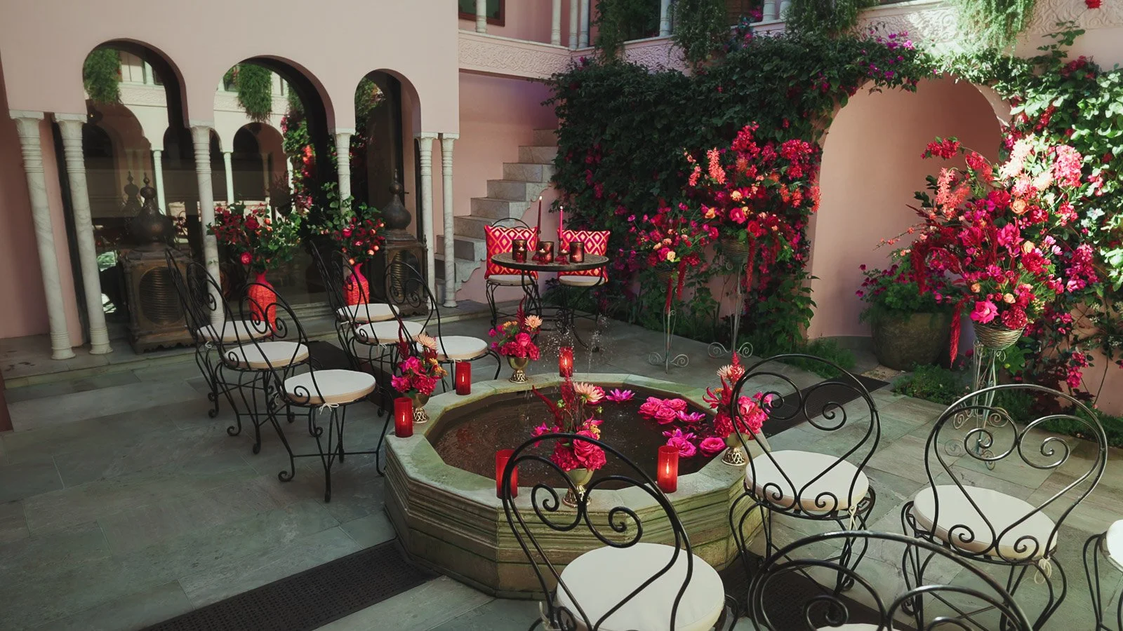 Table scape with pink and red florals, black tie wedding aesthetic in a courtyard