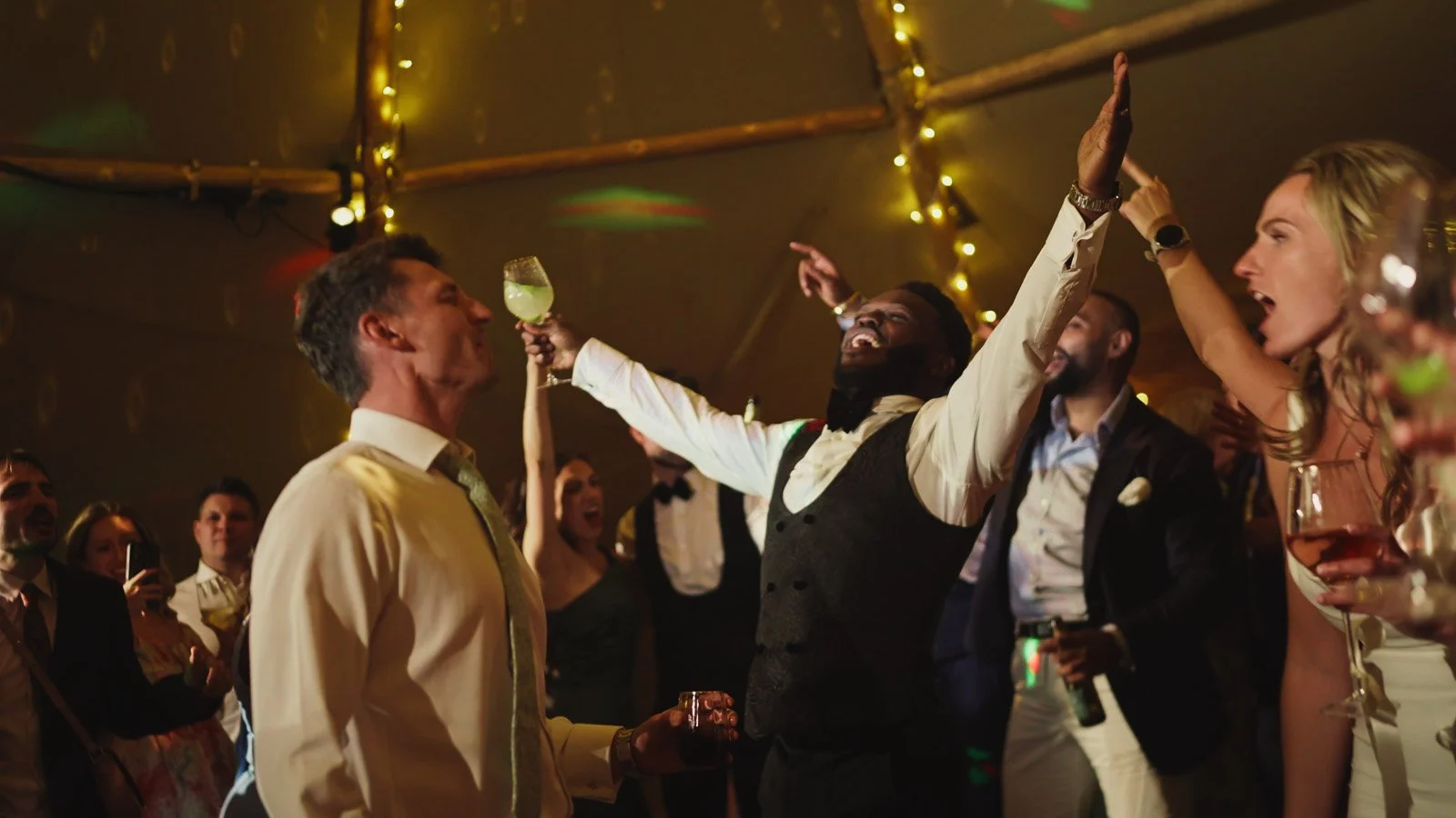 Editorial-style wedding photography from a colourful riverside celebration with bold florals and a marquee reception.