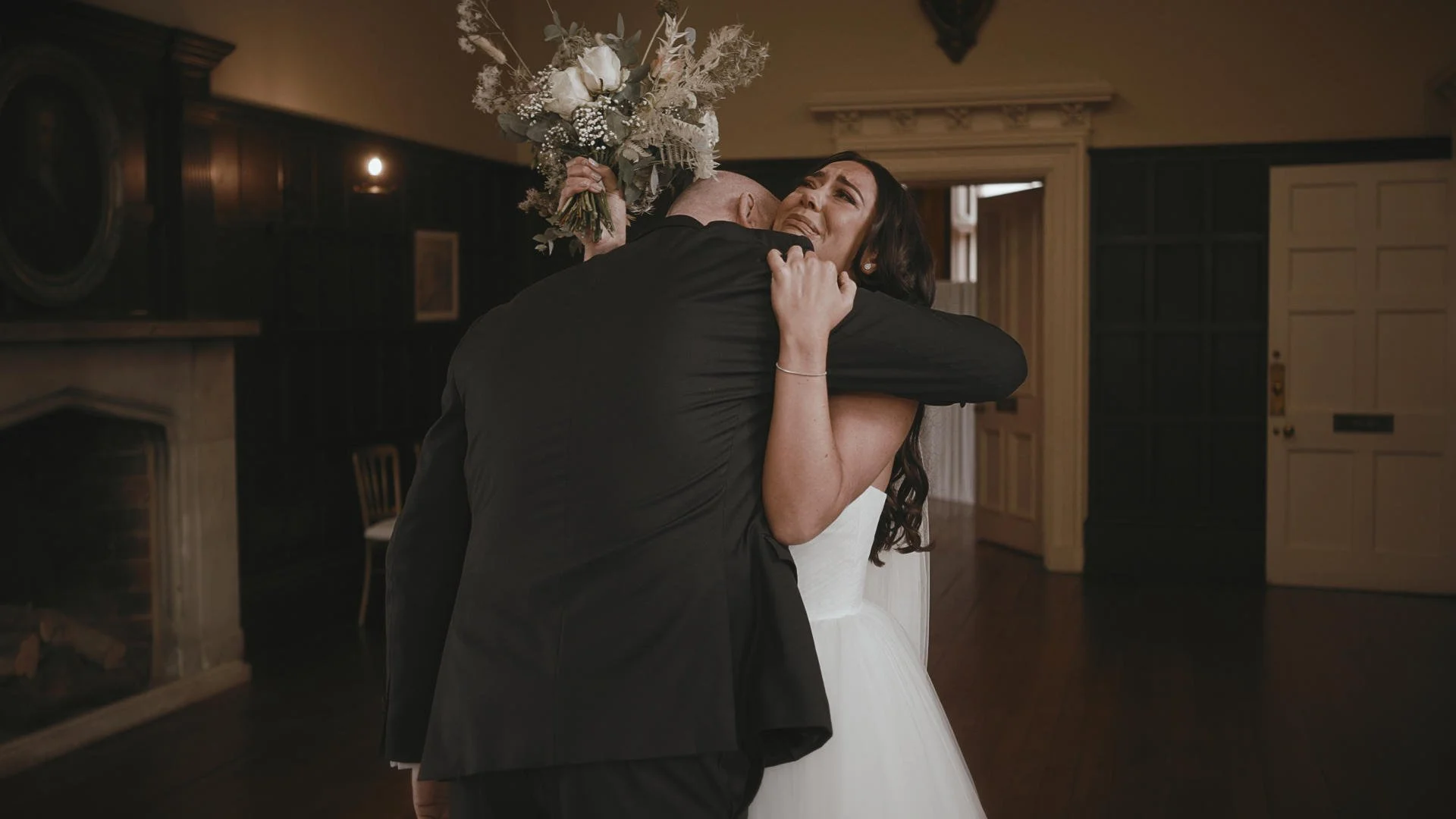 An emotional moment during a bespoke cinematic wedding film as a bride embraces her father during morning preparations.