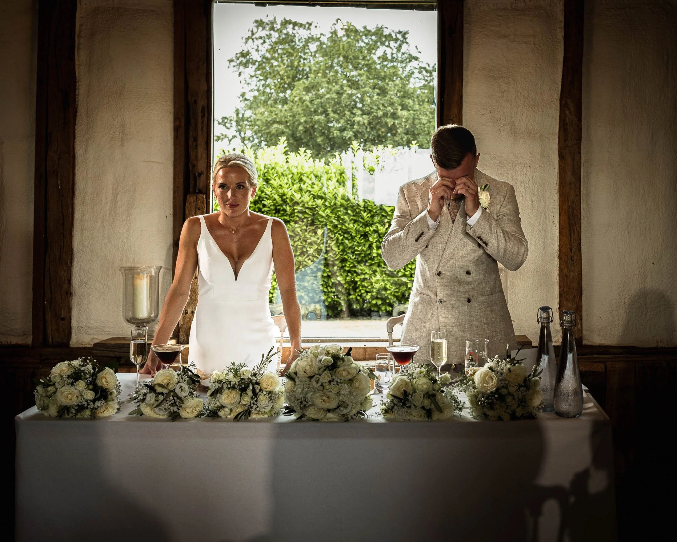 An emotive moment during wedding speeches at Winters Barns in Kent, where the groom is crying next to his bride at the top table.