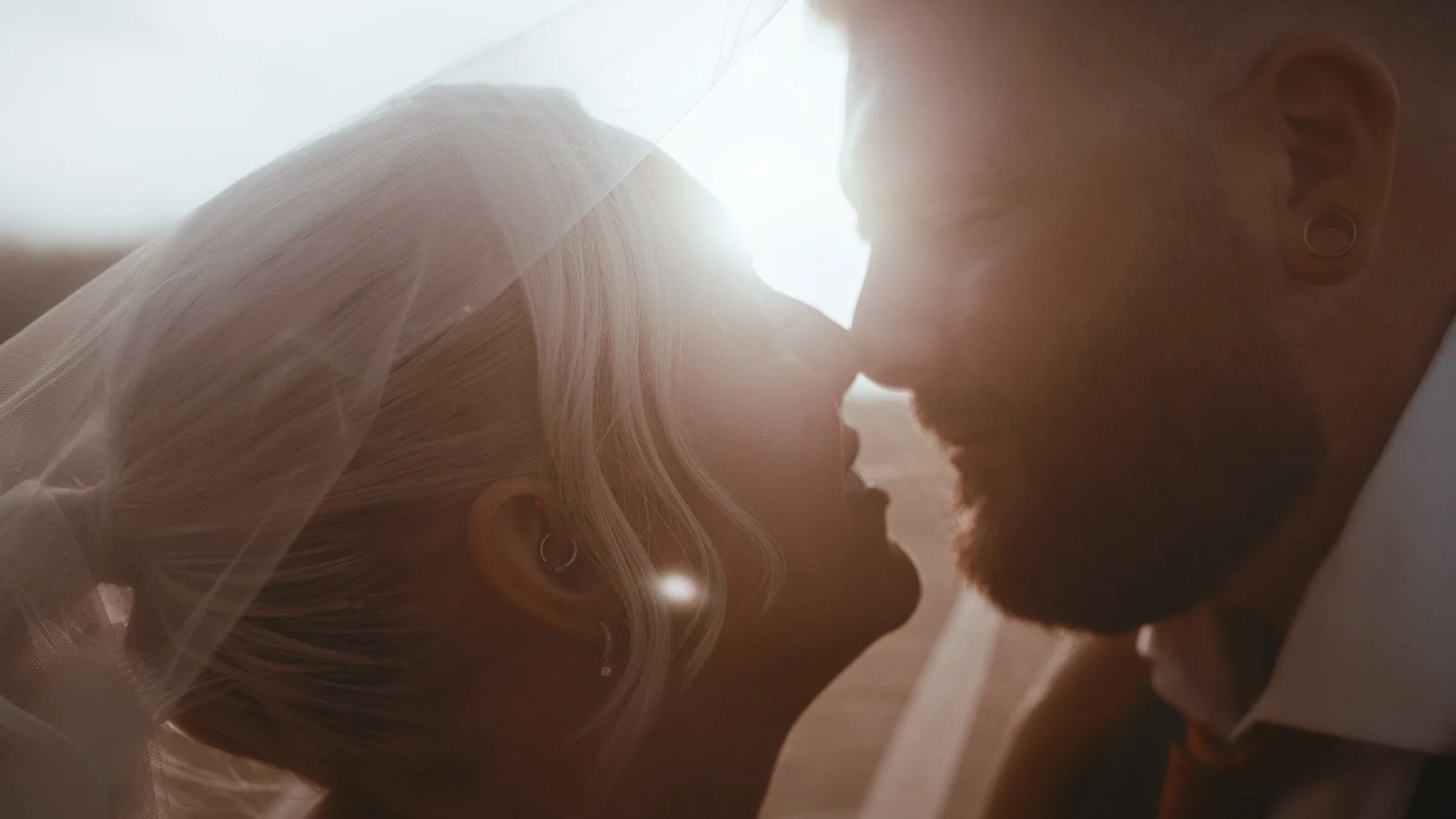 Sunset kiss in the Kent countryside after a Winters Barns wedding, shot in an editorial cinematic style.