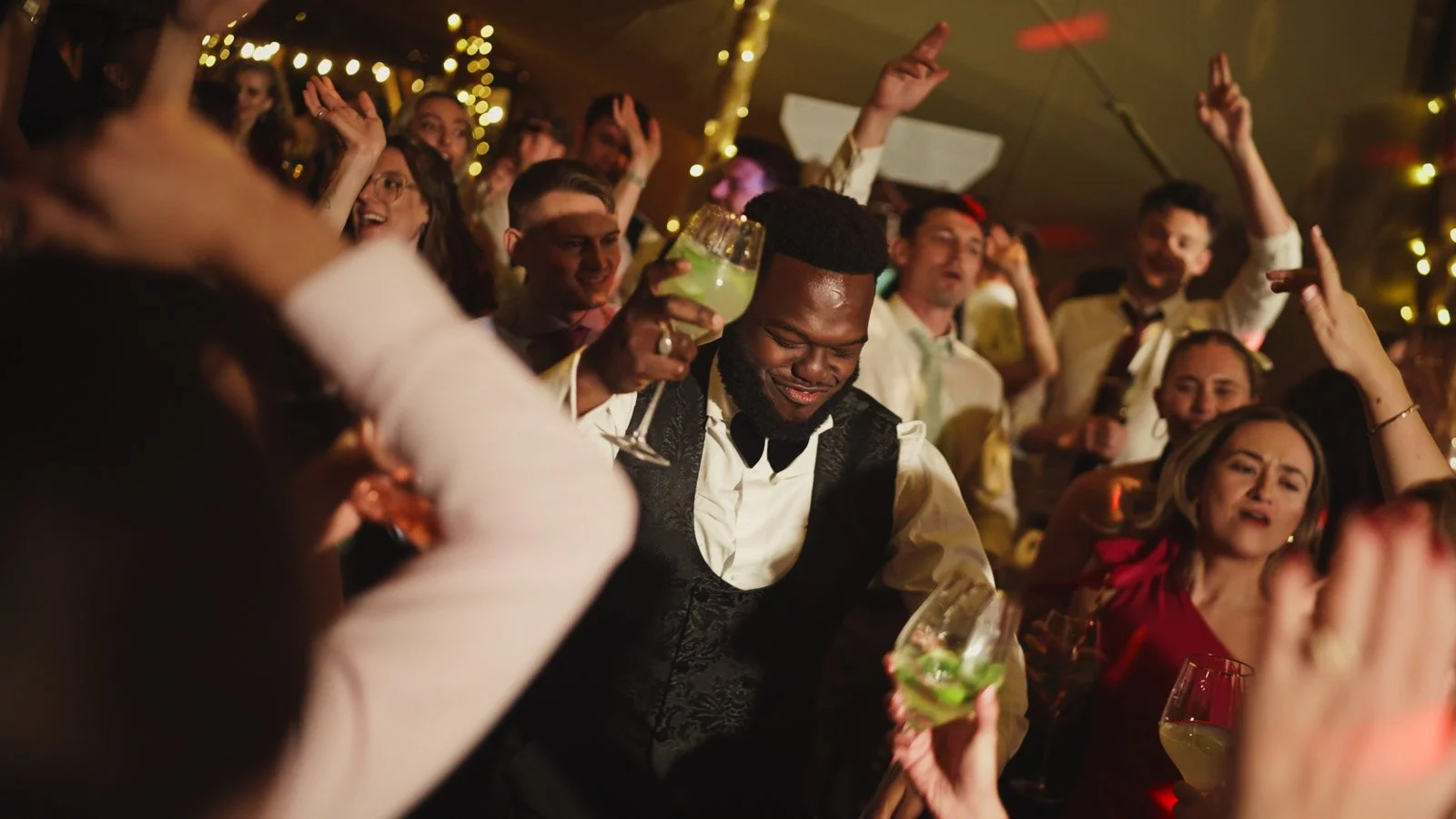 A live band plays during this dance floor moment with the groom at a colourful riverside wedding reception.