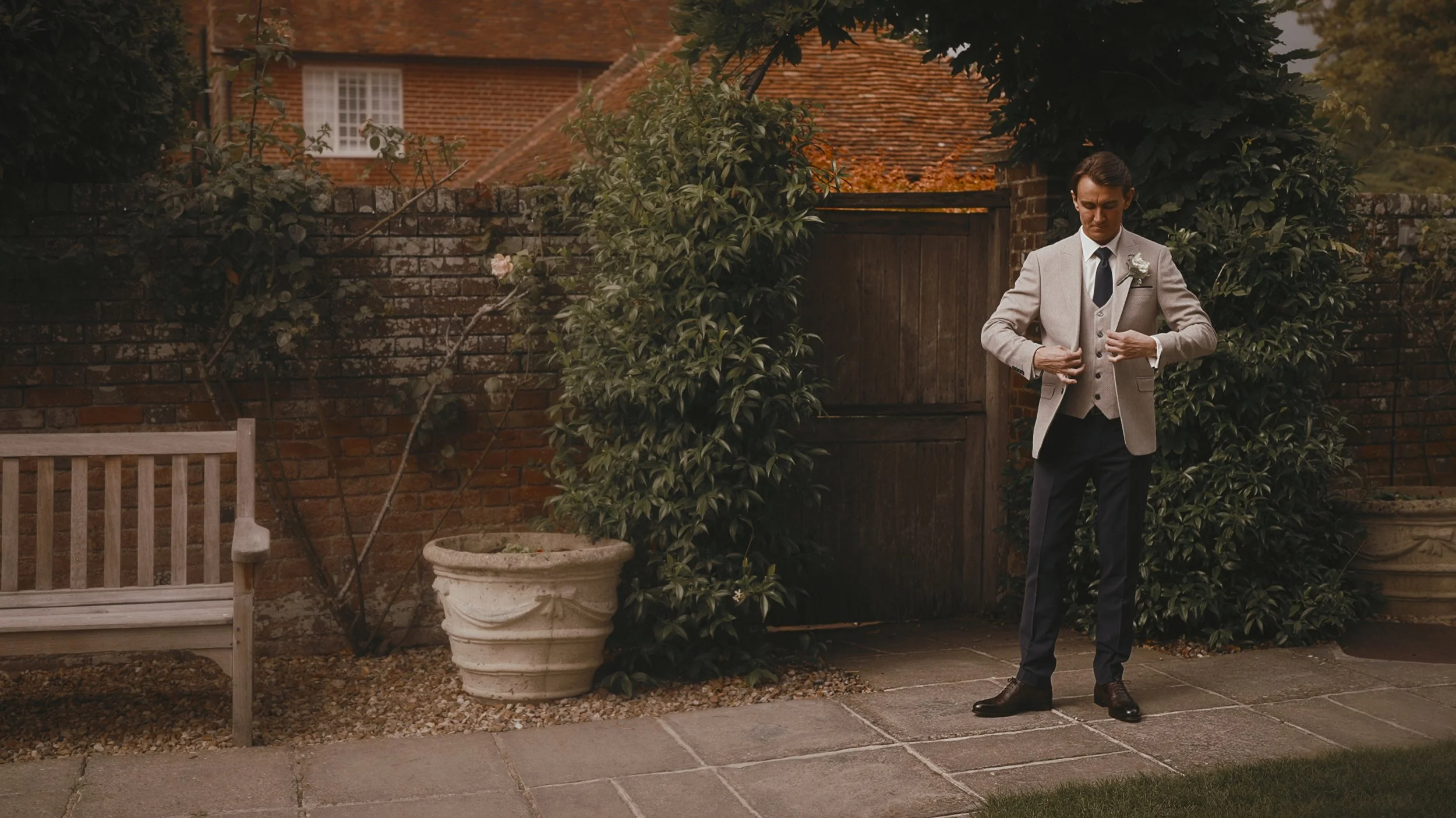 Editorial portrait of a groom adjusting his jacket in a Winters Barns September wedding video.