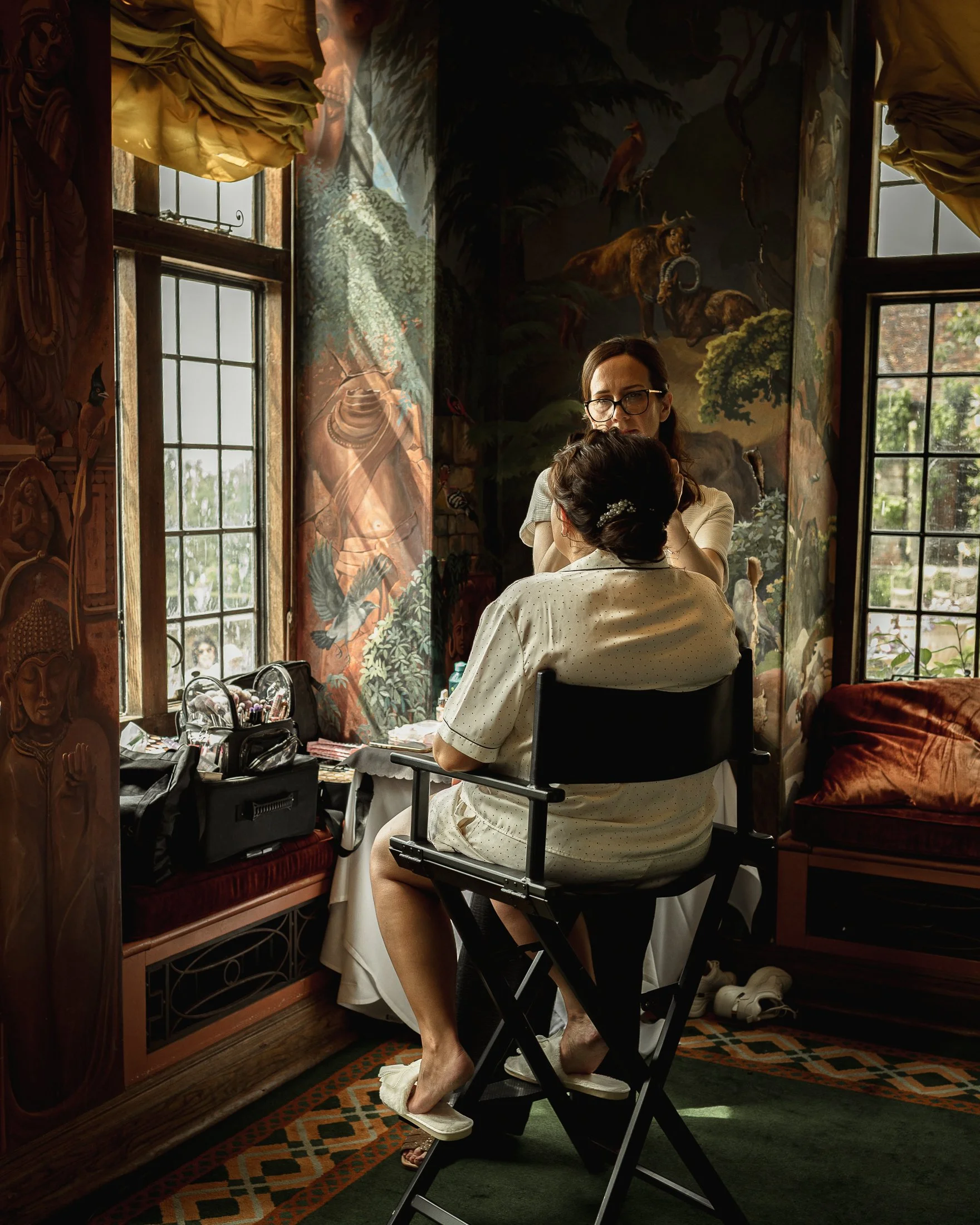 A bridal prep moment in a room full of animal murals at Port Lympne Hotel.