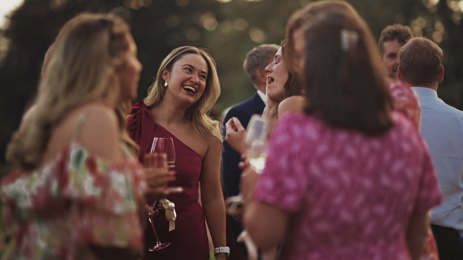 A candid moment of a guest in a marquee during a colourful riverside wedding reception.