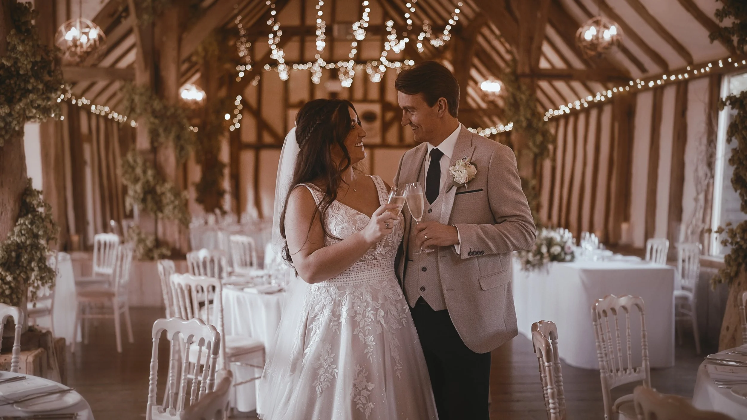 An editorial shot of a bride and groom toasting Champagne in the main barn at Winters Barns during their September wedding.