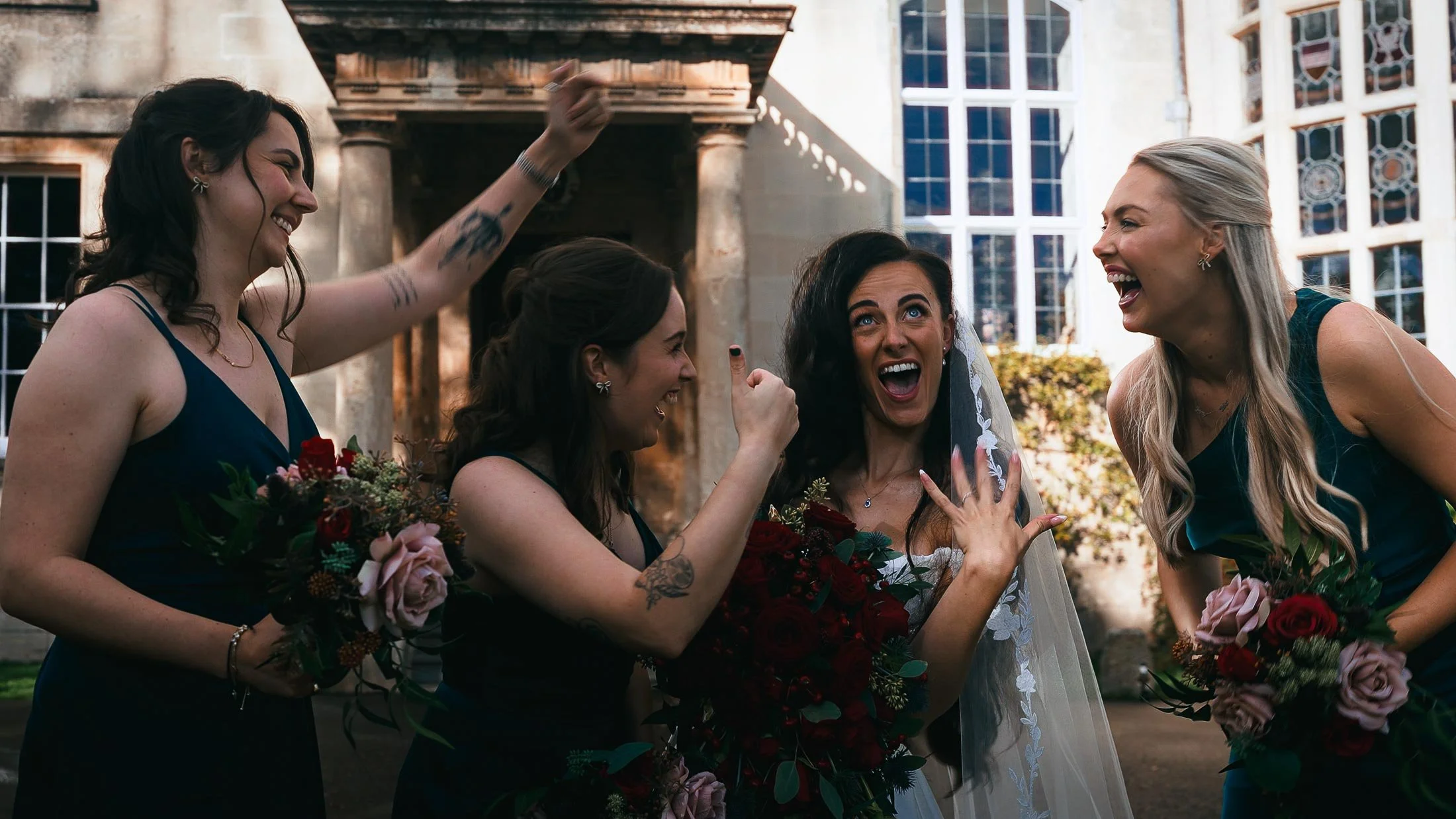 Bride celebrates and flashes her wedding ring to her bridesmaids.