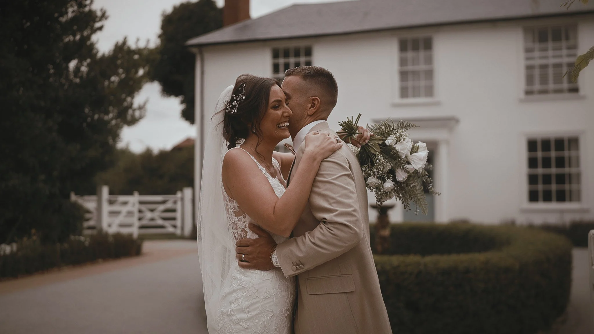 A couple portrait with the Vaulty Manor mansion in the background, framed for a cinematic wedding film.