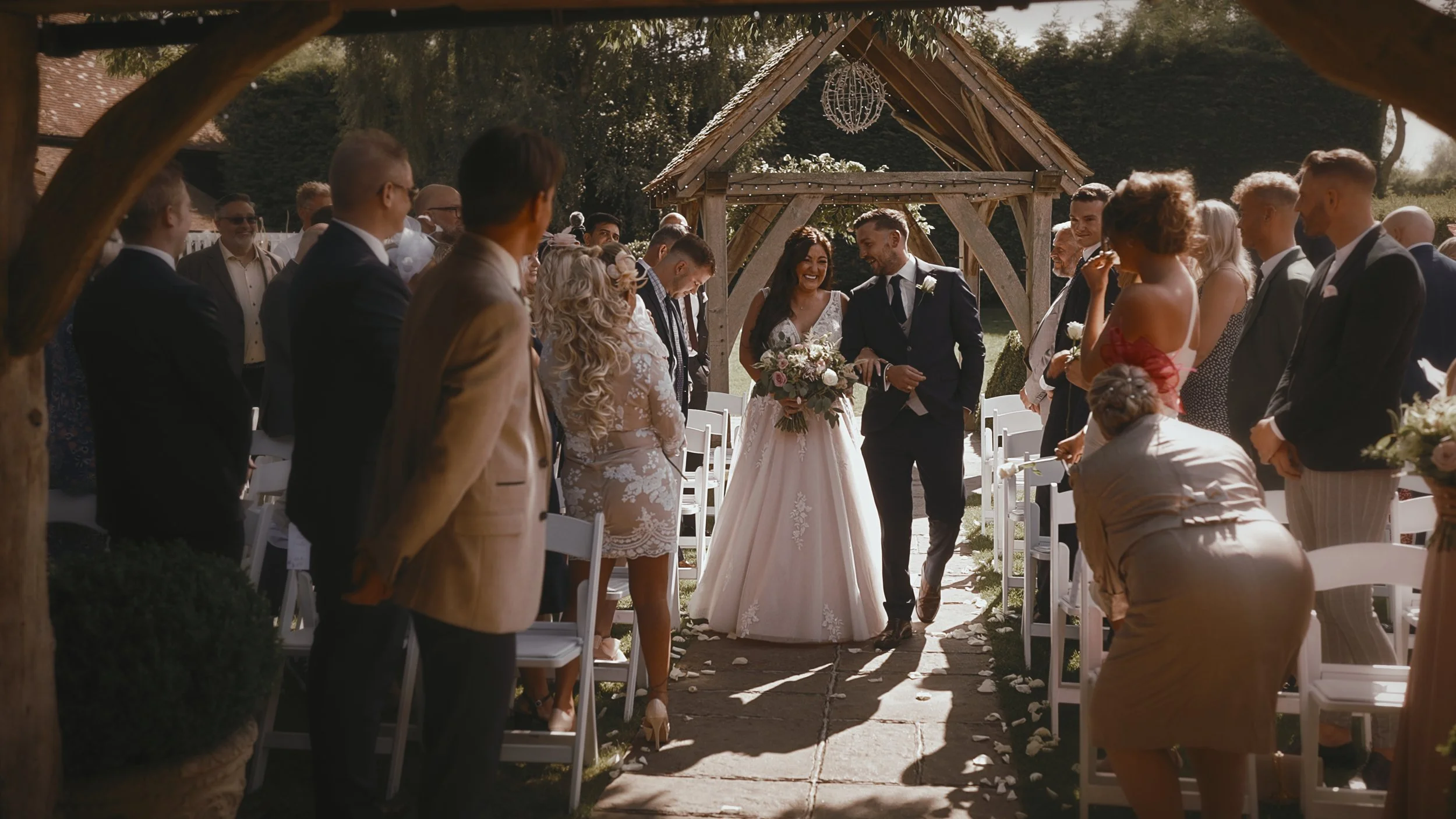 A bride enters an outdoor wedding ceremony in September at Winters Barns in Kent.