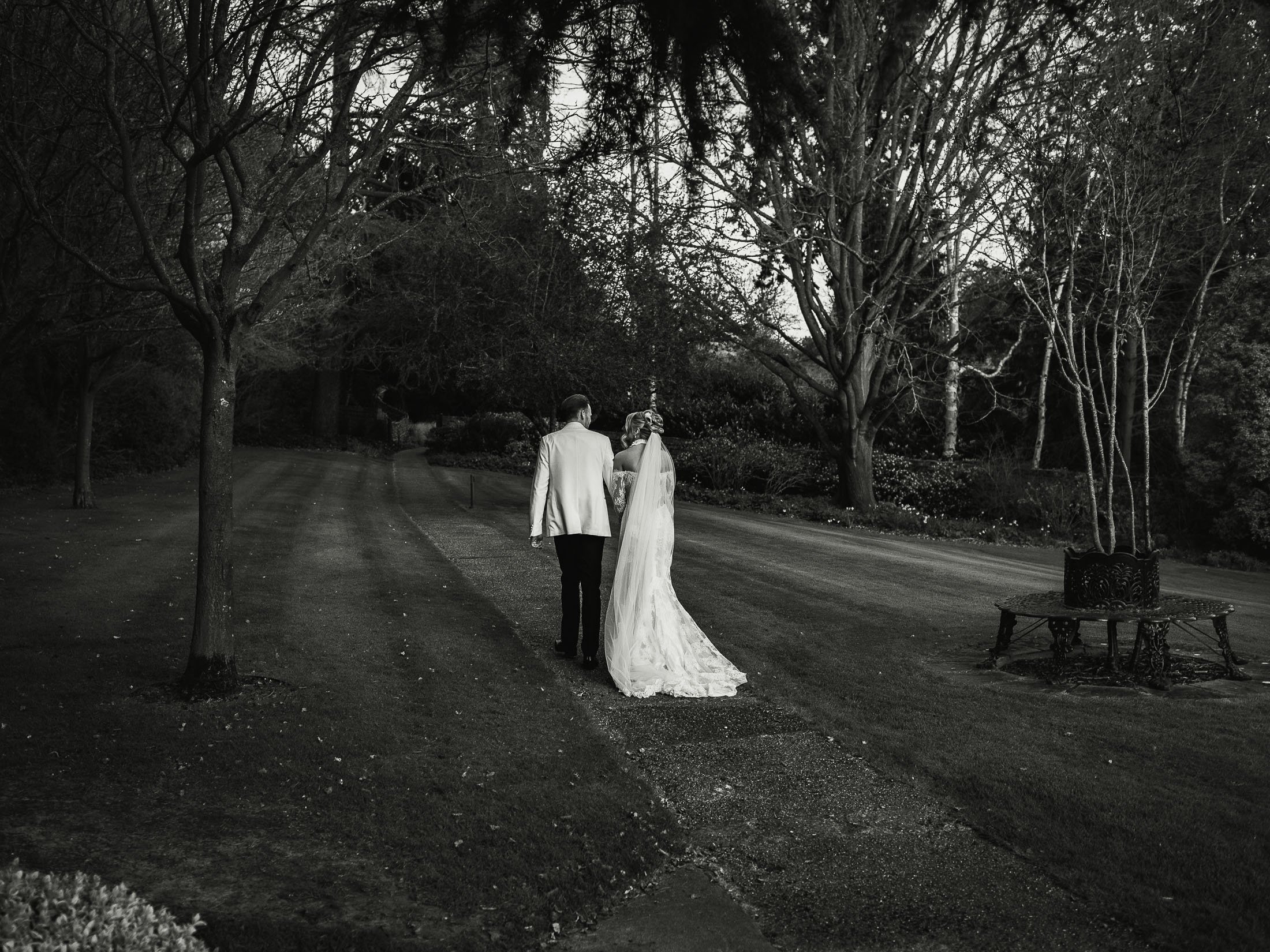 Bride and groom walking through the grounds of The Orangery Maidstone wedding venue.