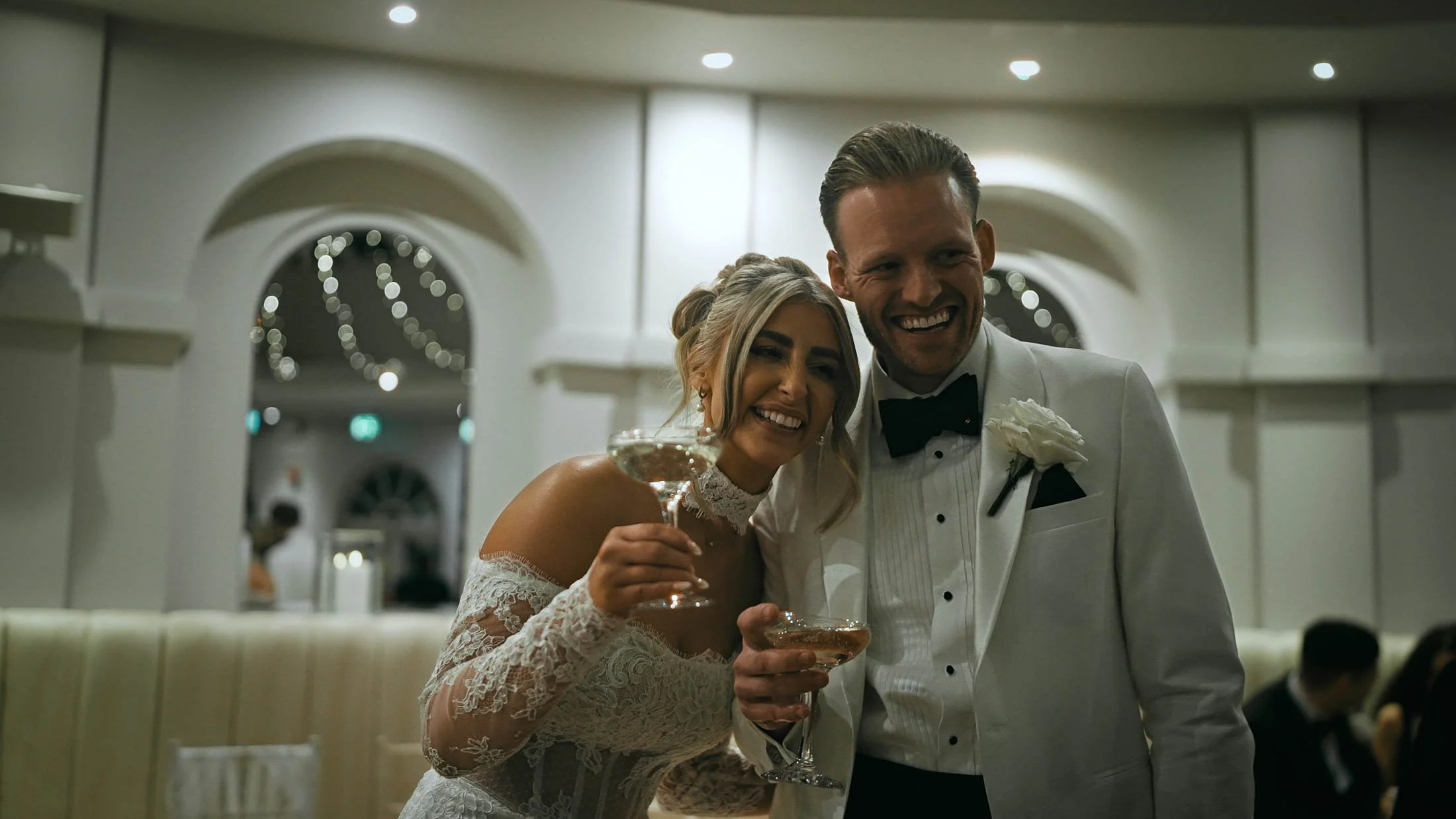 A candid moment of the bride and groom laughing together during cocktail hour.