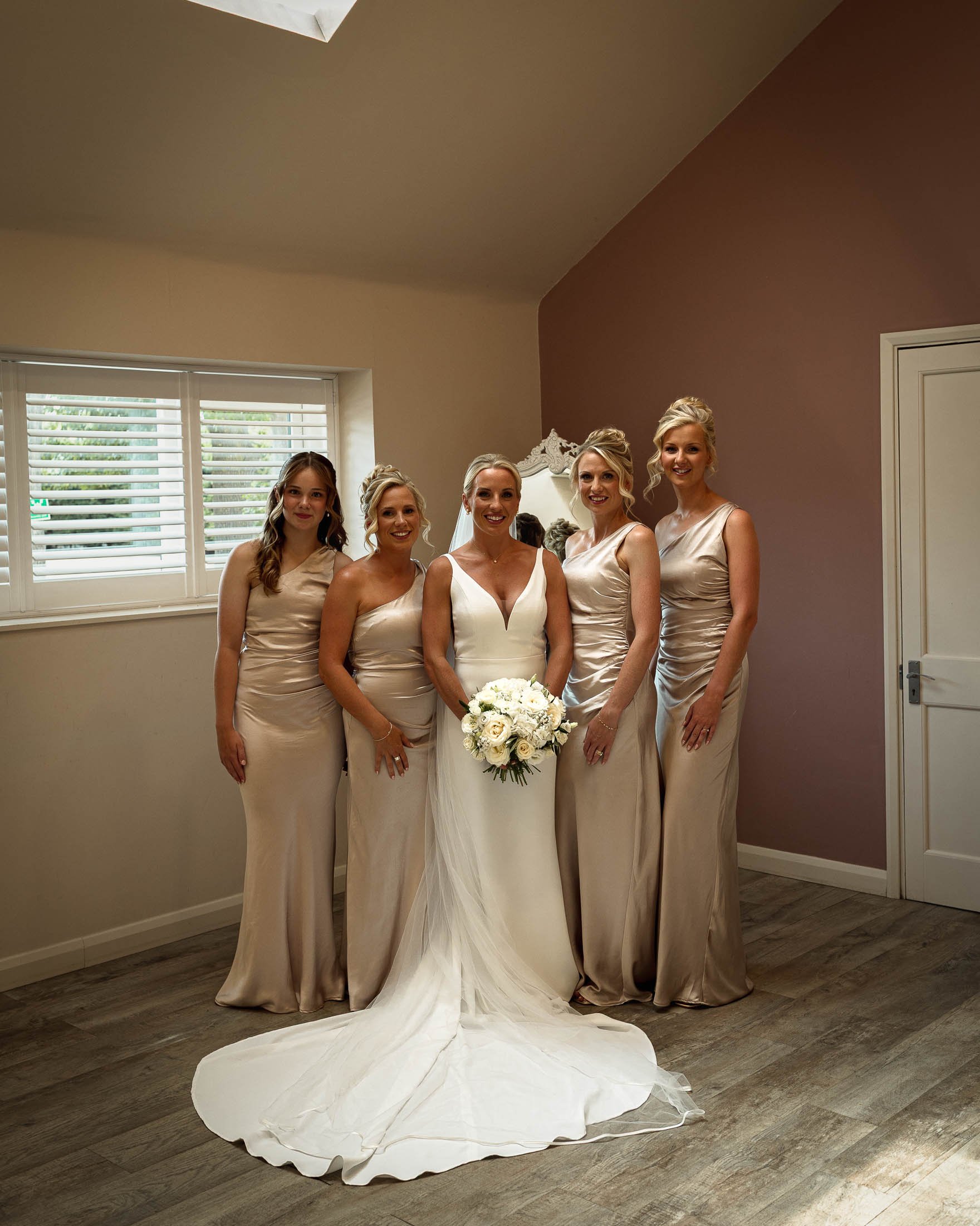 A bride stands with her bridesmaids in the prep room at Winters Barns in Canterbury, Kent, shortly before she leaves for her outdoor wedding ceremony.