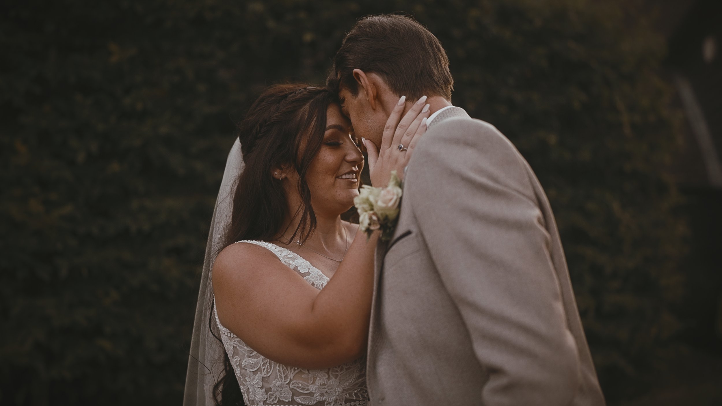 An intimate moment as a bride cradles the face of the groom during golden hour portraits at a September Winters Barns wedding.