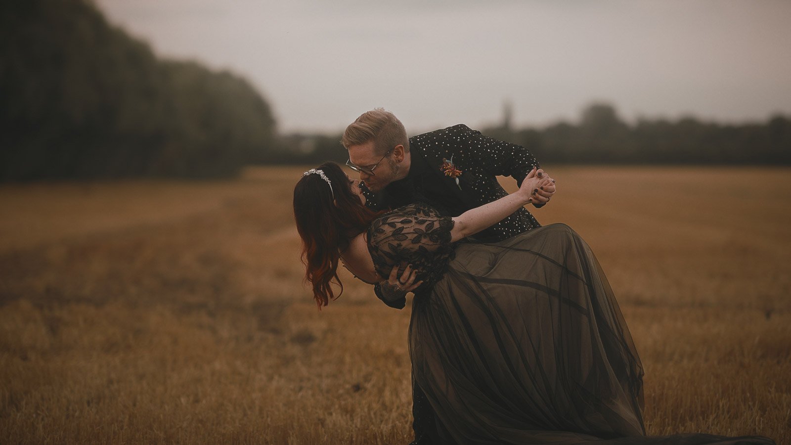 Couple portrait in a field with dramatic dress train for Winters Barns wedding film