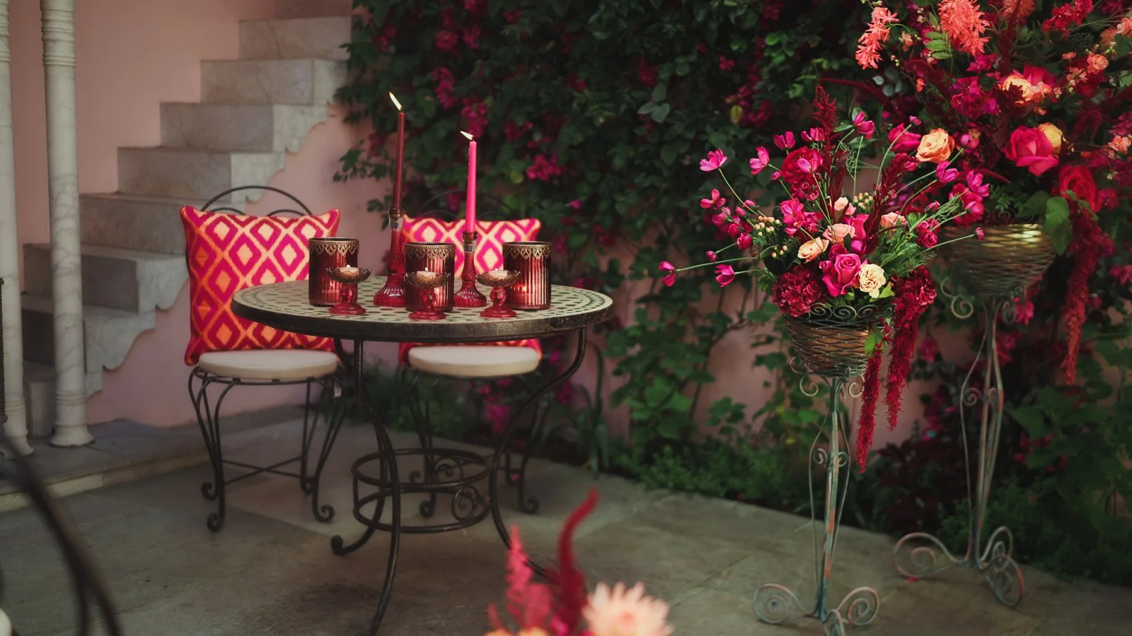 Bright pink and red wedding decor set up in a romantic courtyard backdrop at Port Lympne.