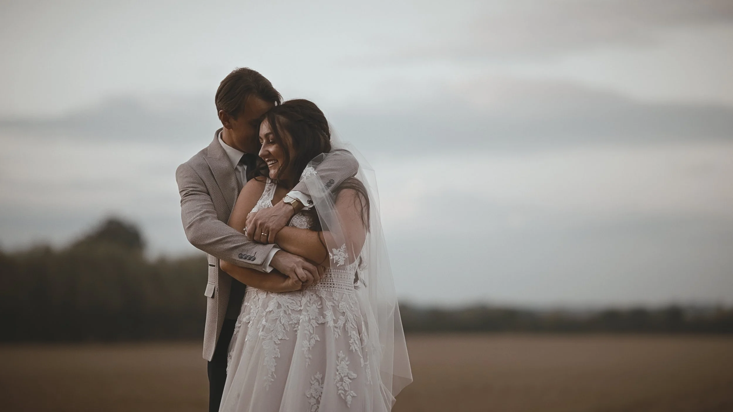 A couple embrace each other lovingly on their romantic September wedding film at Winters Barns.