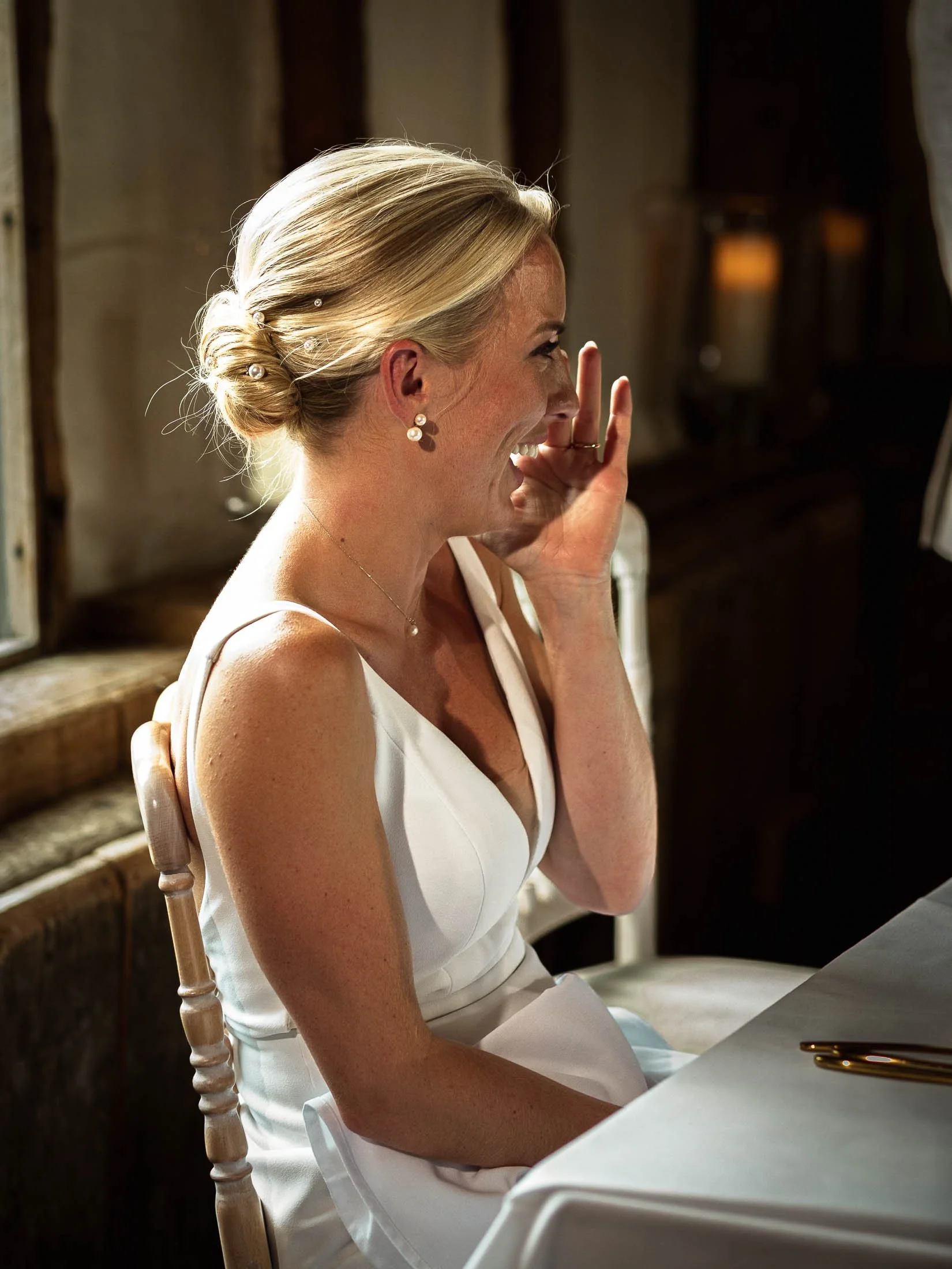 A bride laughs during wedding speeches at Winters Barns.