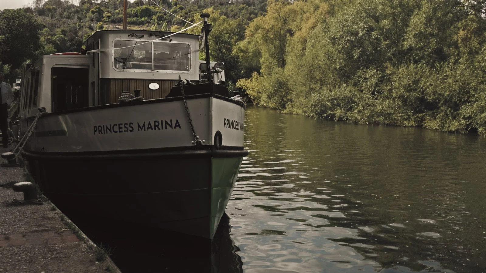 Editorial-style wedding photography from a colourful riverside celebration with bold florals and a marquee reception.