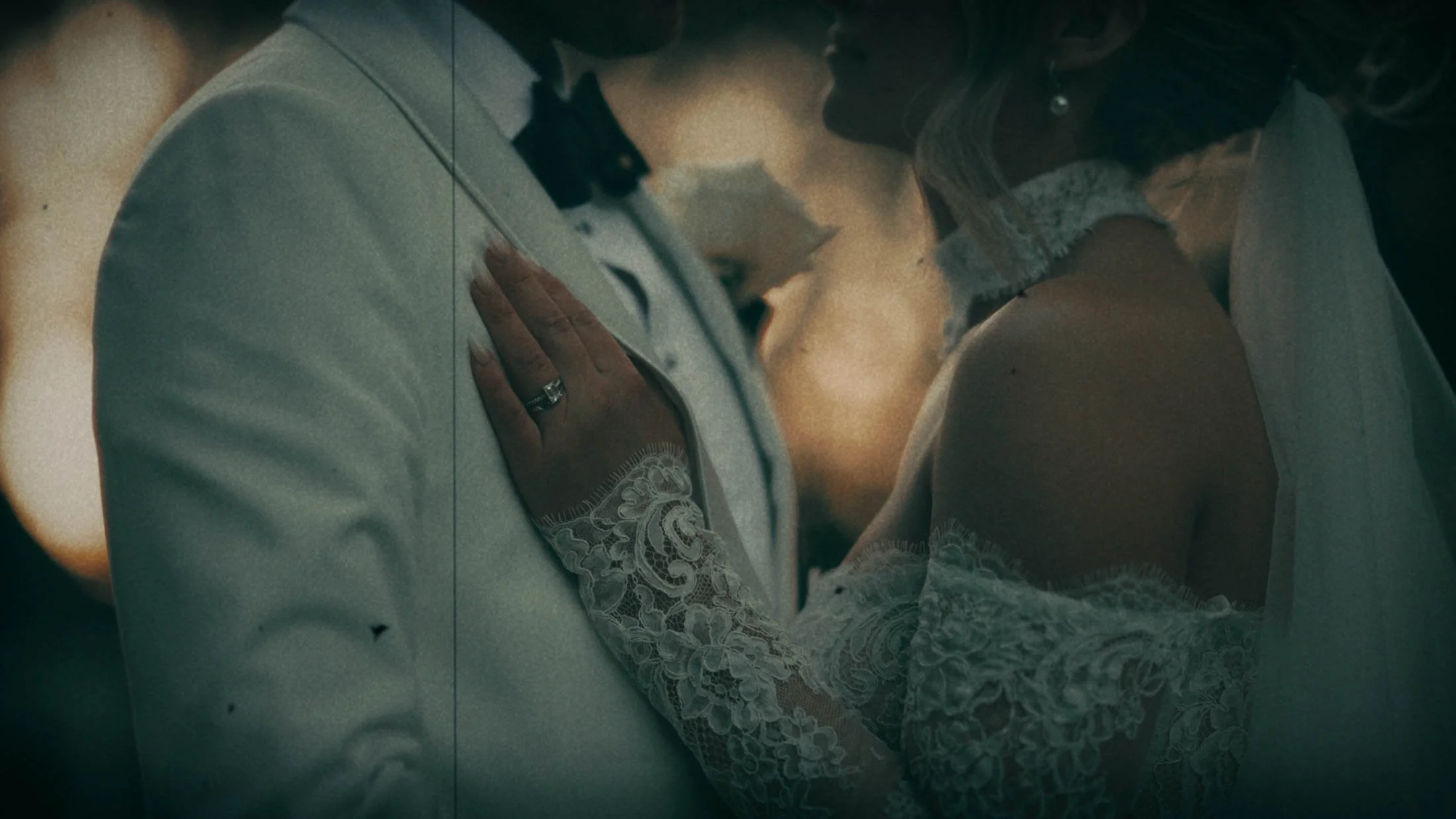 A bride rests her hand on the grooms chest during a Super 8mm emulation section of their storytelling wedding film in the UK.