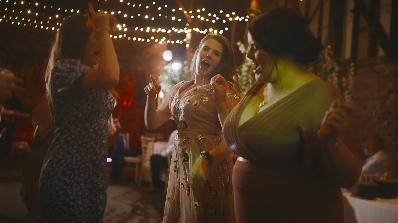Guests dance during a high-energy moment in a Cooling Castle Barn sunset wedding film.