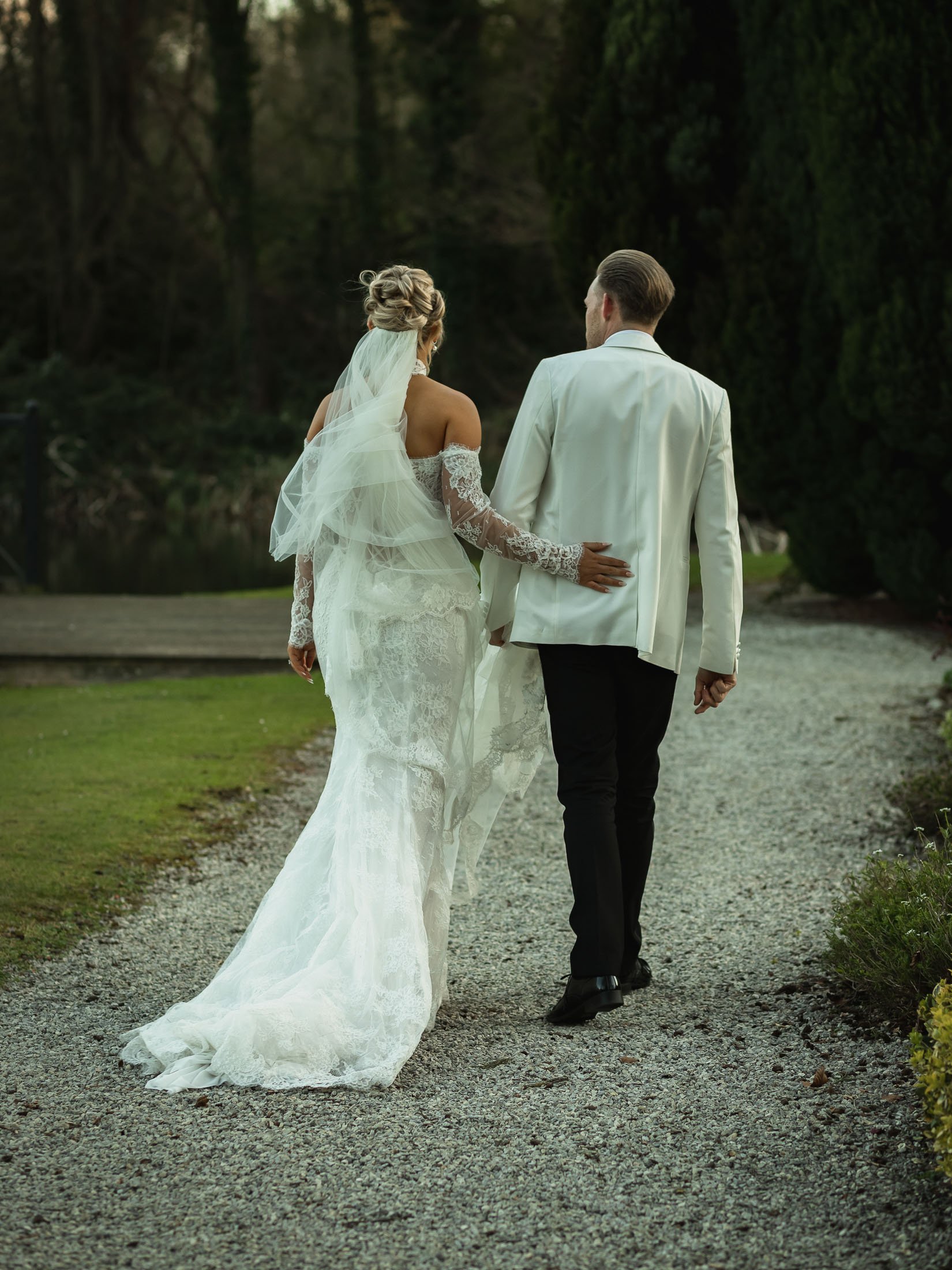 A romantic moment between a bride and groom as they walk through the grounds of The Orangery in Kent.
