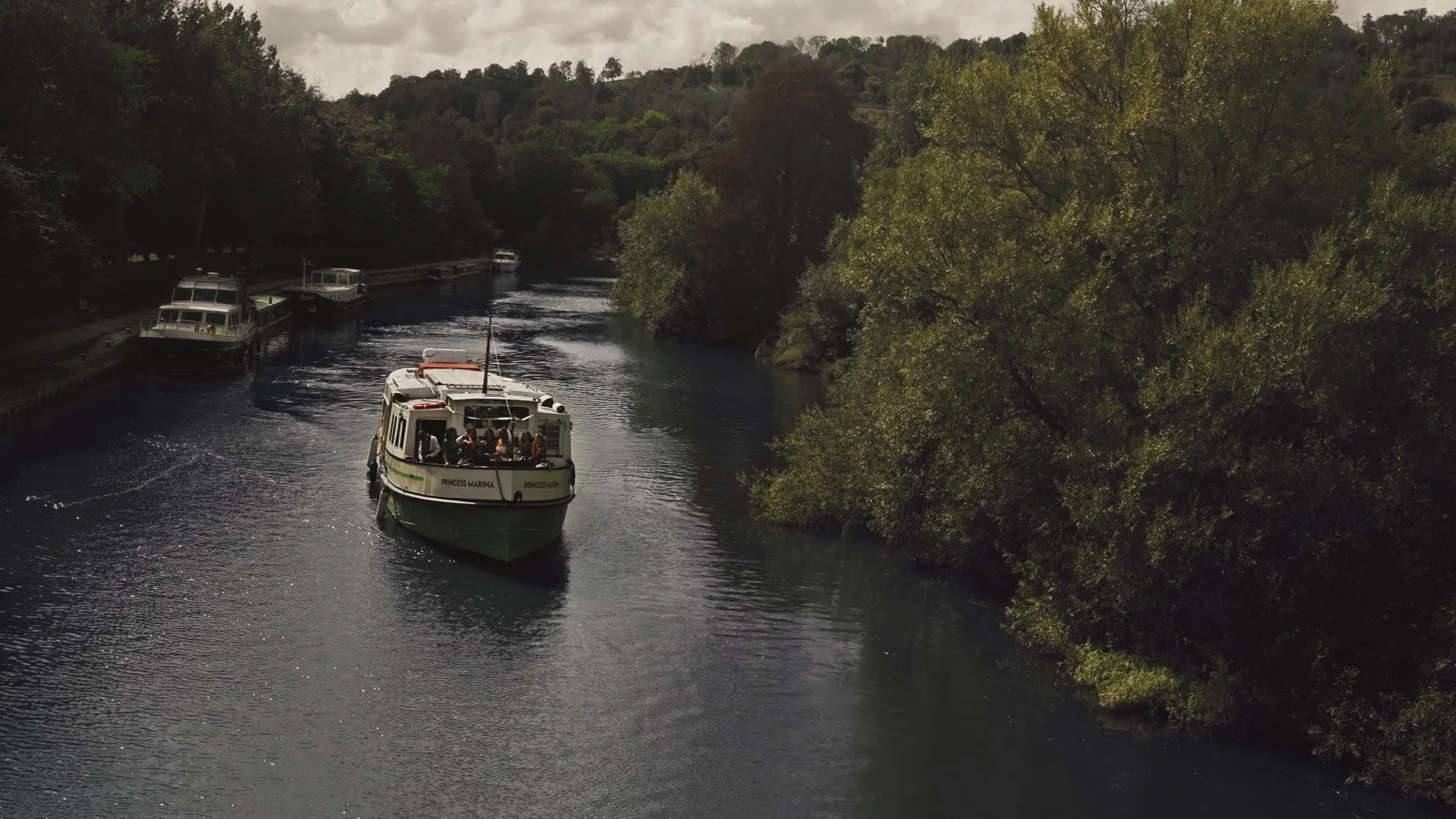 A bridal party take a boat ride along the River Thames to and Oxfordshire Estate for a colourful riverside wedding.