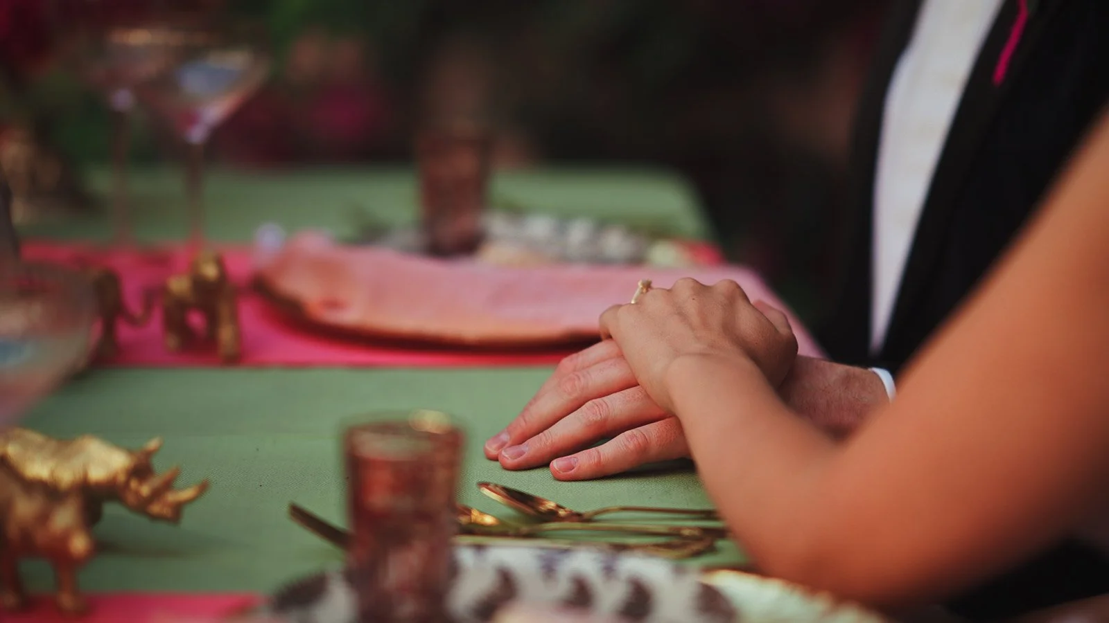 Fine art wedding aesthetic with bold colour accents and timeless composition as the couple hold hands during their reception.